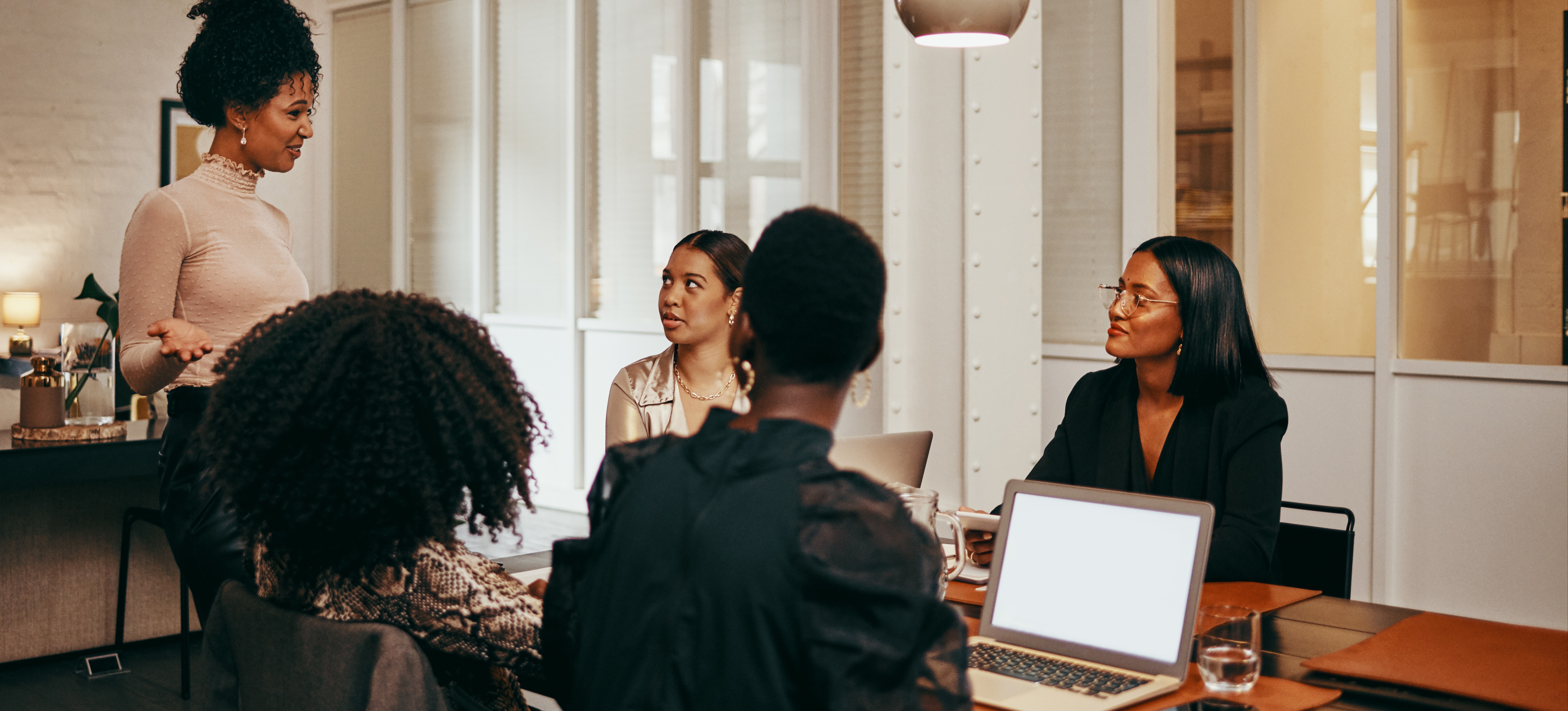 [Featured Image] A professional leads a meeting in a workplace environment and explains Agile development tools to the team.
