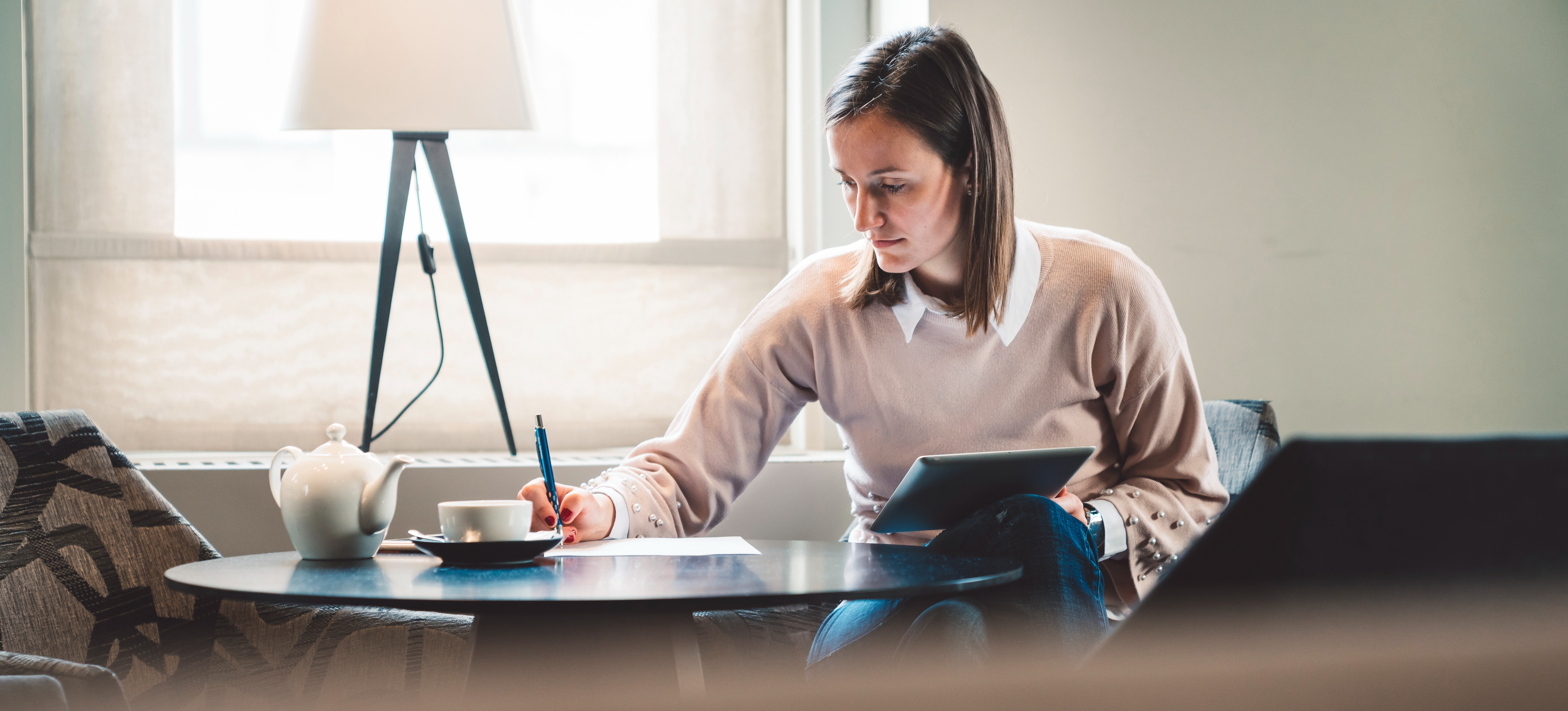 [Image en vedette] Femme à un bureau travaillant sur une évaluation immobilière