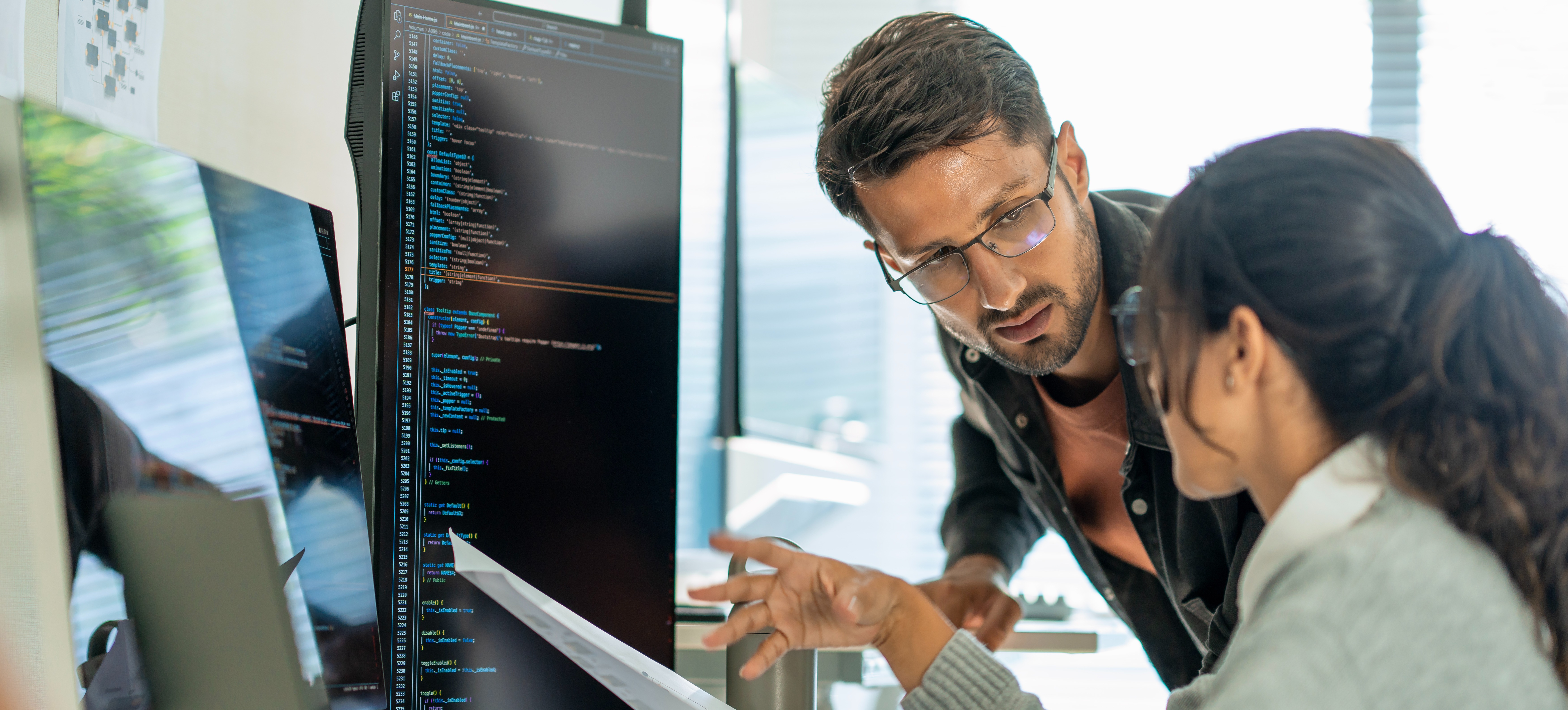 [Featured Image]: Two people in front of a computer collaborate on feature engineering for machine learning models to improve prediction accuracy.
