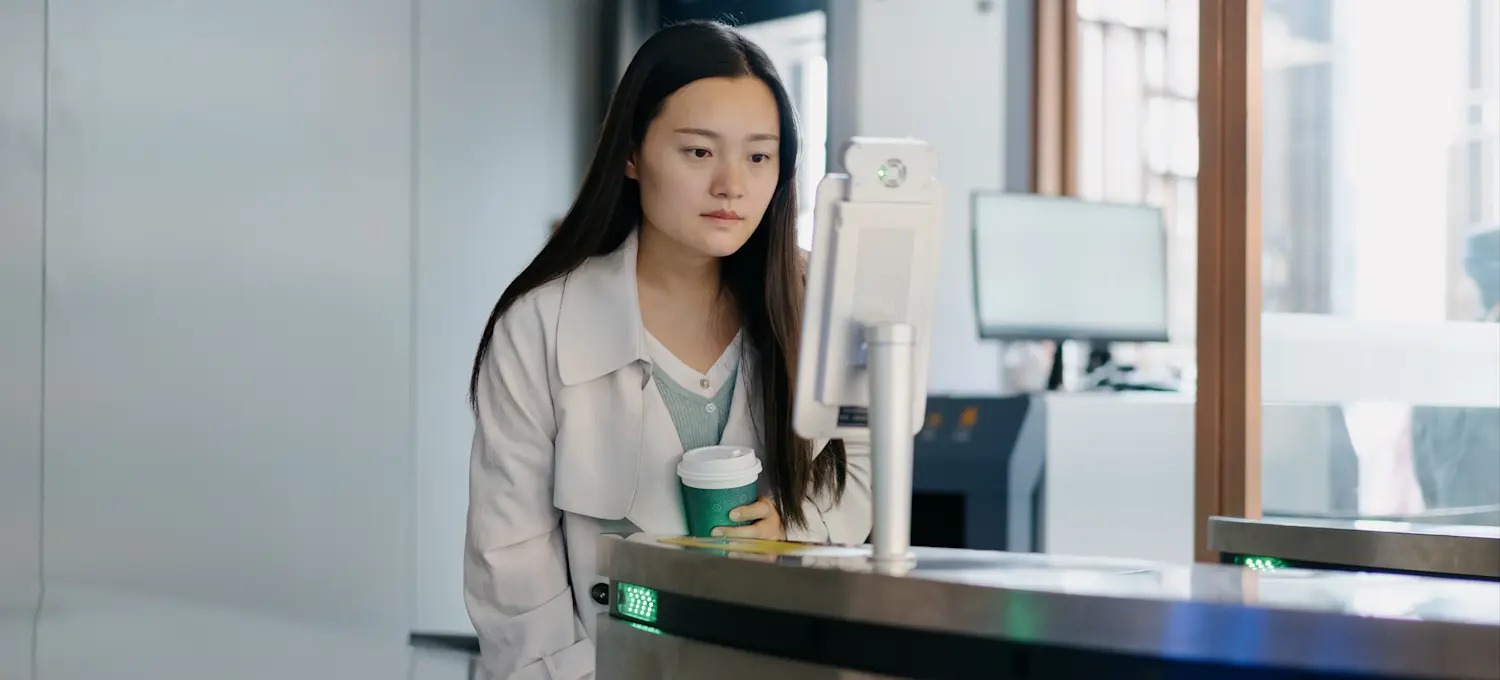 [Featured Image] A person holding coffee and monitoring cybersecurity in a health care environment.
