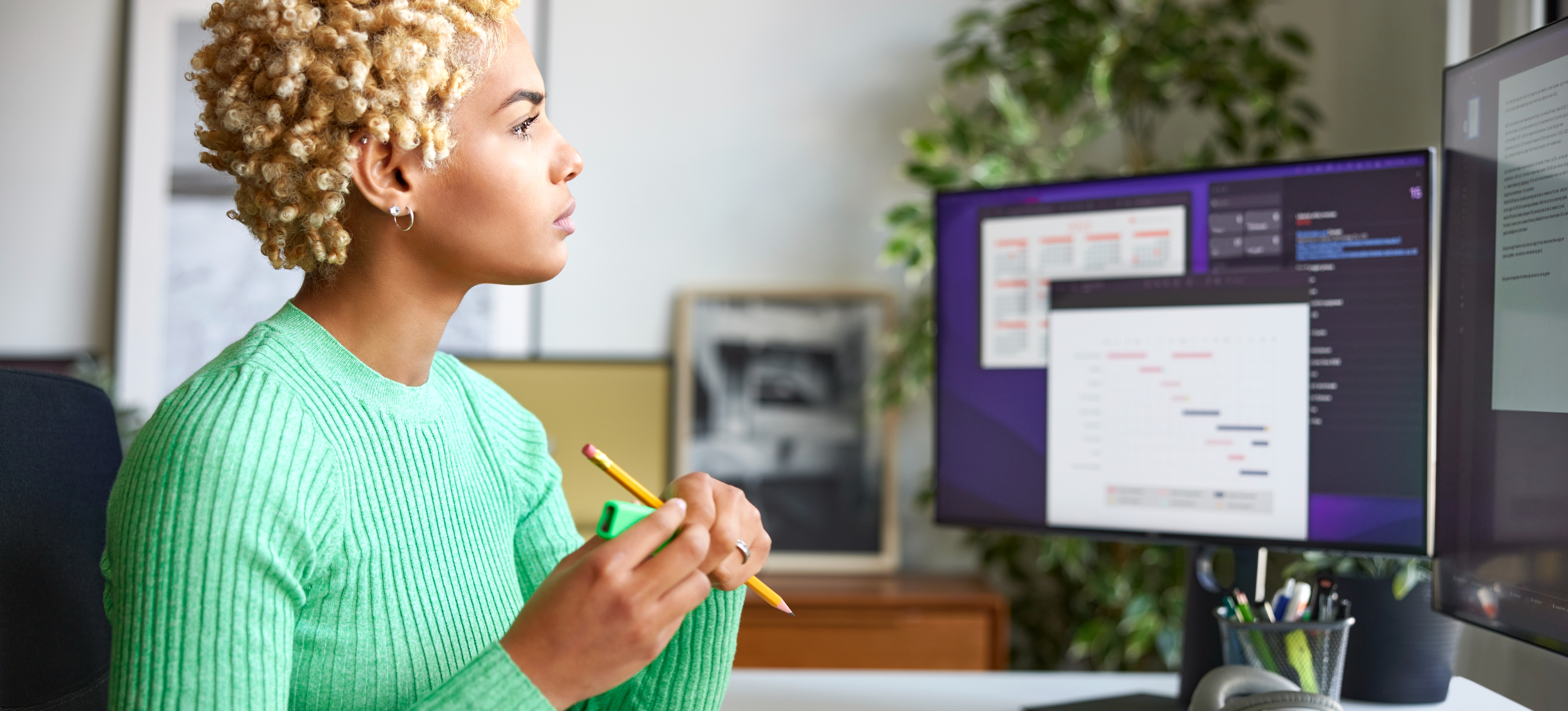 [Featured image] A confident professional wearing a green sweater is working in their home office and calculating how many work weeks are in a year.
