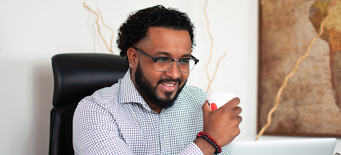 [Featured Image] A programmer looks at their laptop while holding a cup of coffee and explores various r data types. 