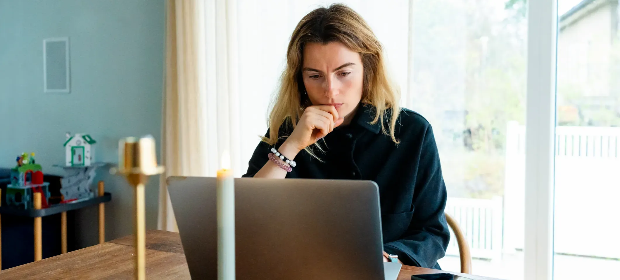 [Featured Image] A young professional works to improve their AI literacy by experimenting with different types of prompts while working with an AI tool on their laptop at home.

