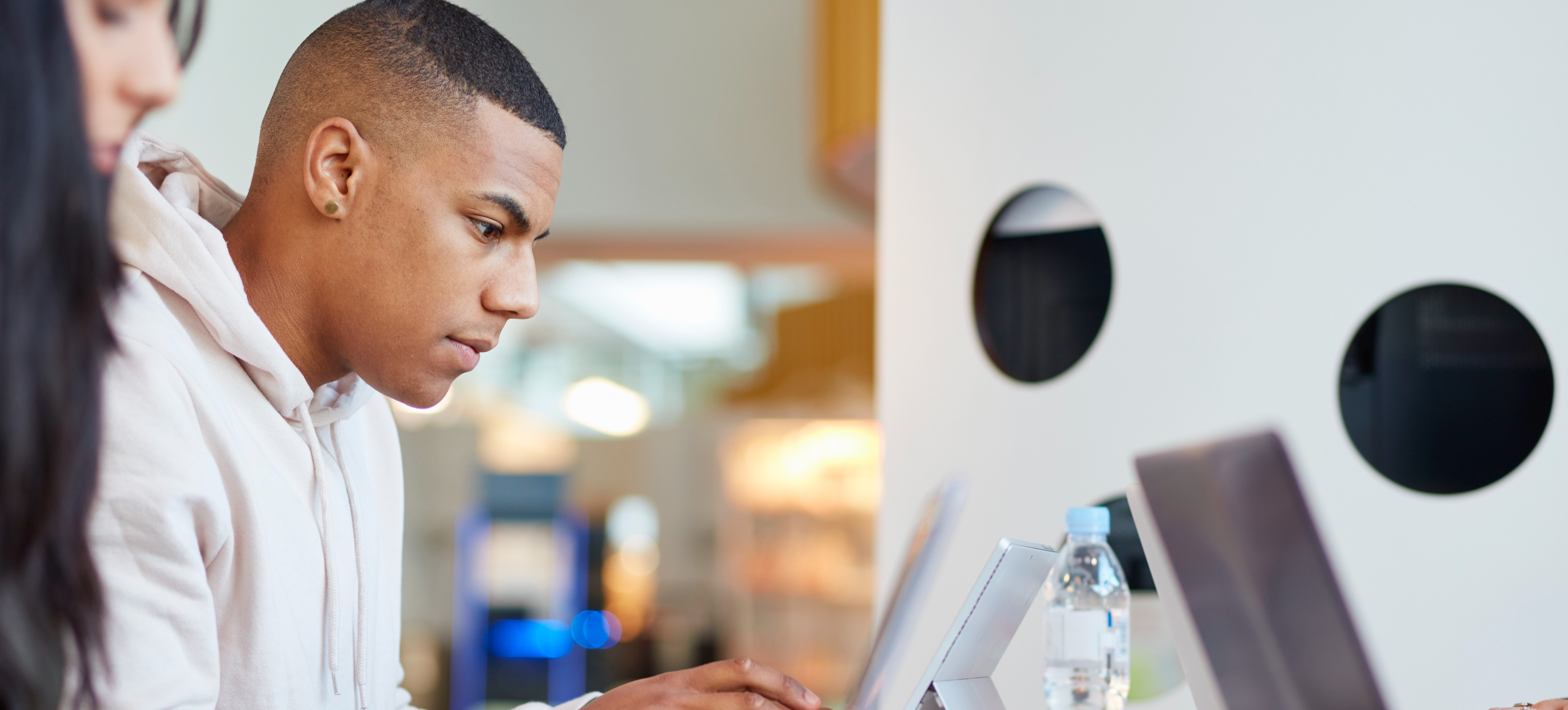 [Features Image] Students doing postsecondary education work on computers in a classroom.
