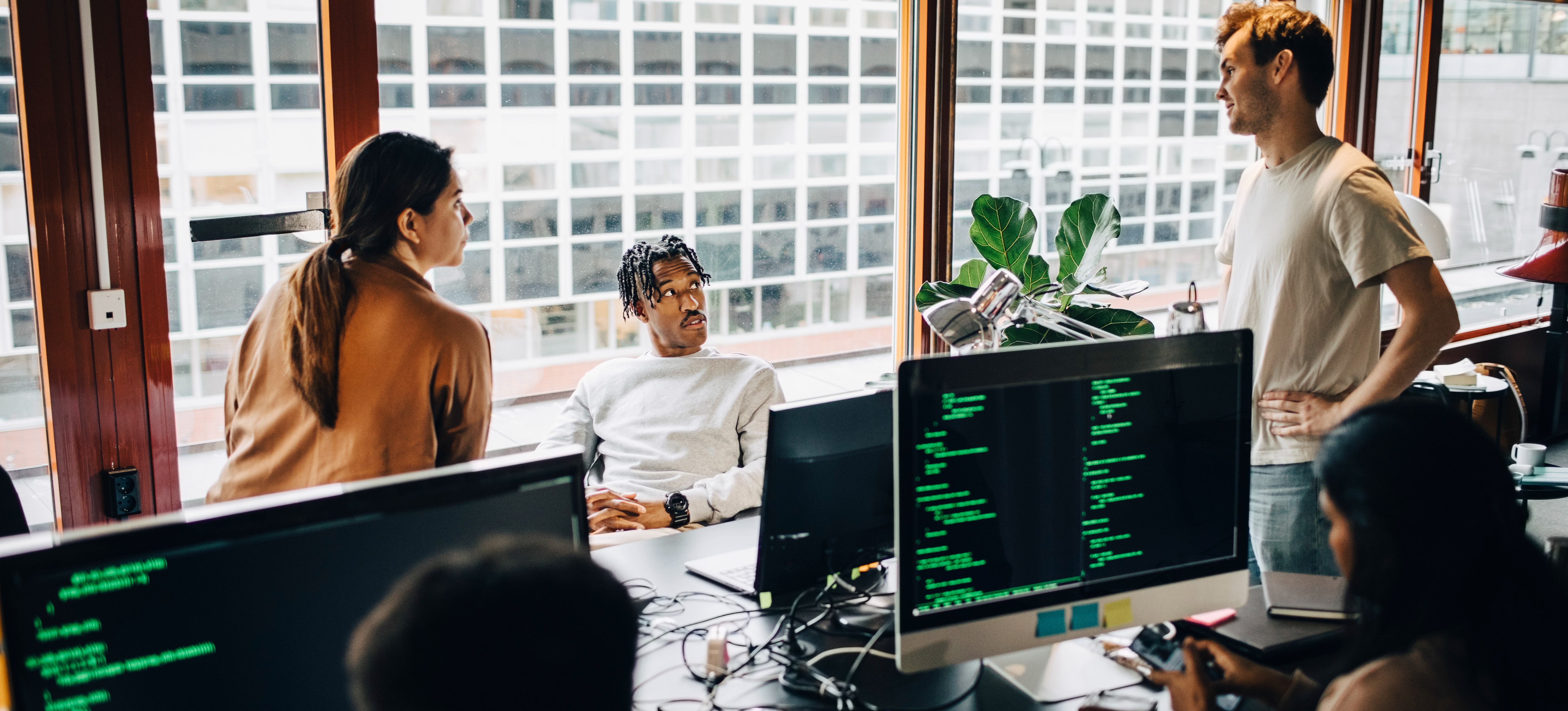 [Featured Image] Three business leaders are meeting in their office, discussing the security of data while cautiously integrating generative AI into the daily tasks.
