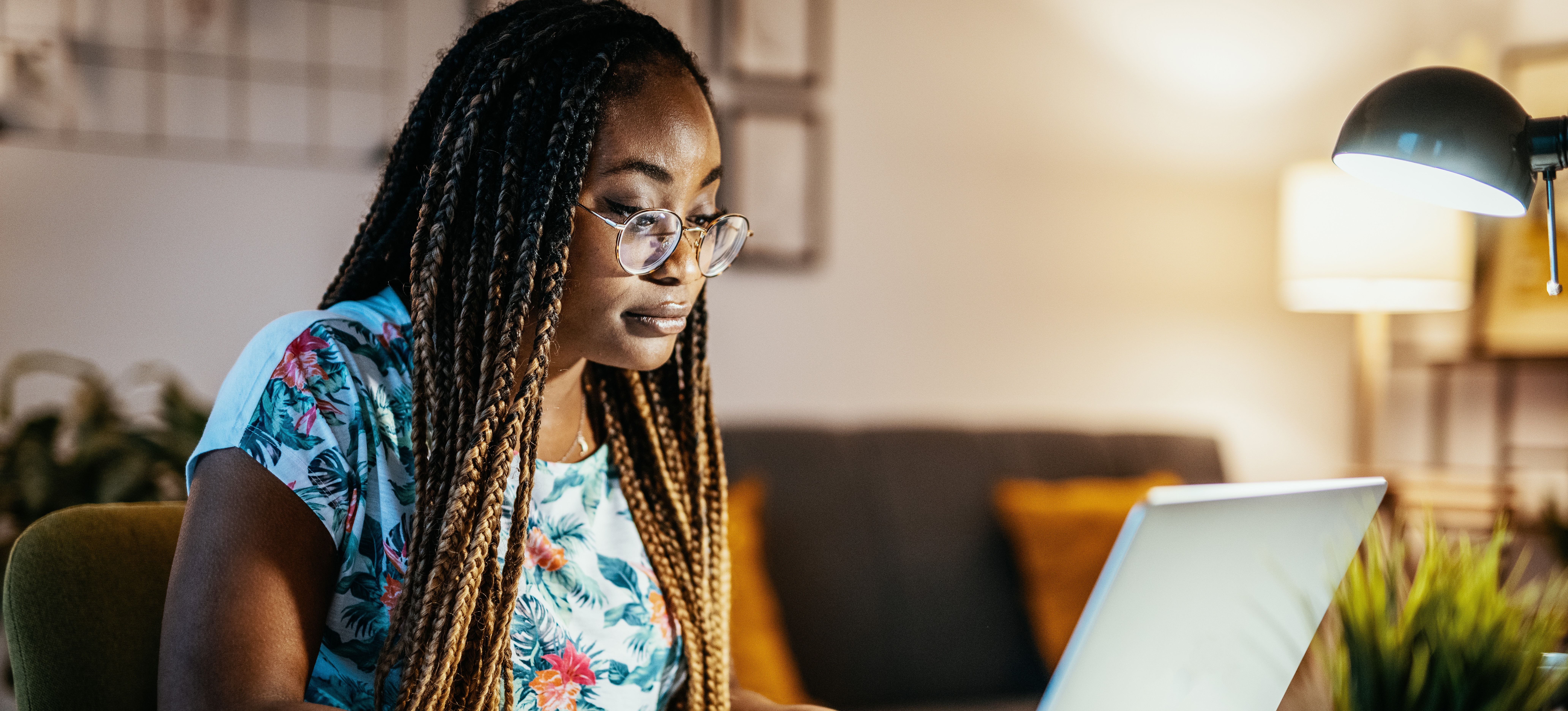 [Hauptbild] Eine Person mit Brille verwendet einen KI-Chatbot auf ihrem Laptop, während sie von ihrem Homeoffice aus arbeitet.