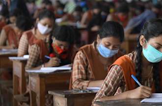 Students are seen writing their examinations.