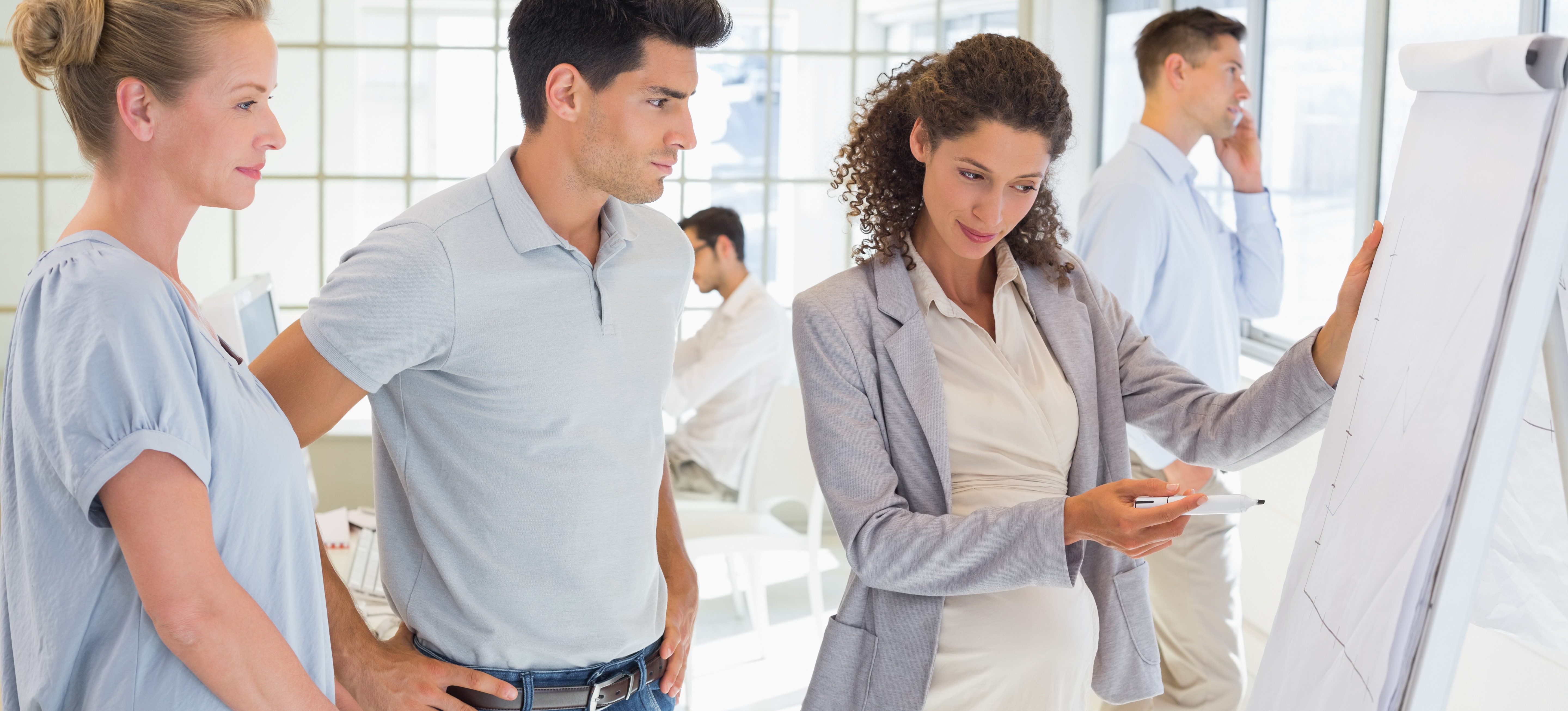 [Featured Image] A cybersecurity project manager, one of the many non-technical cybersecurity jobs, presents some information to their team. 
