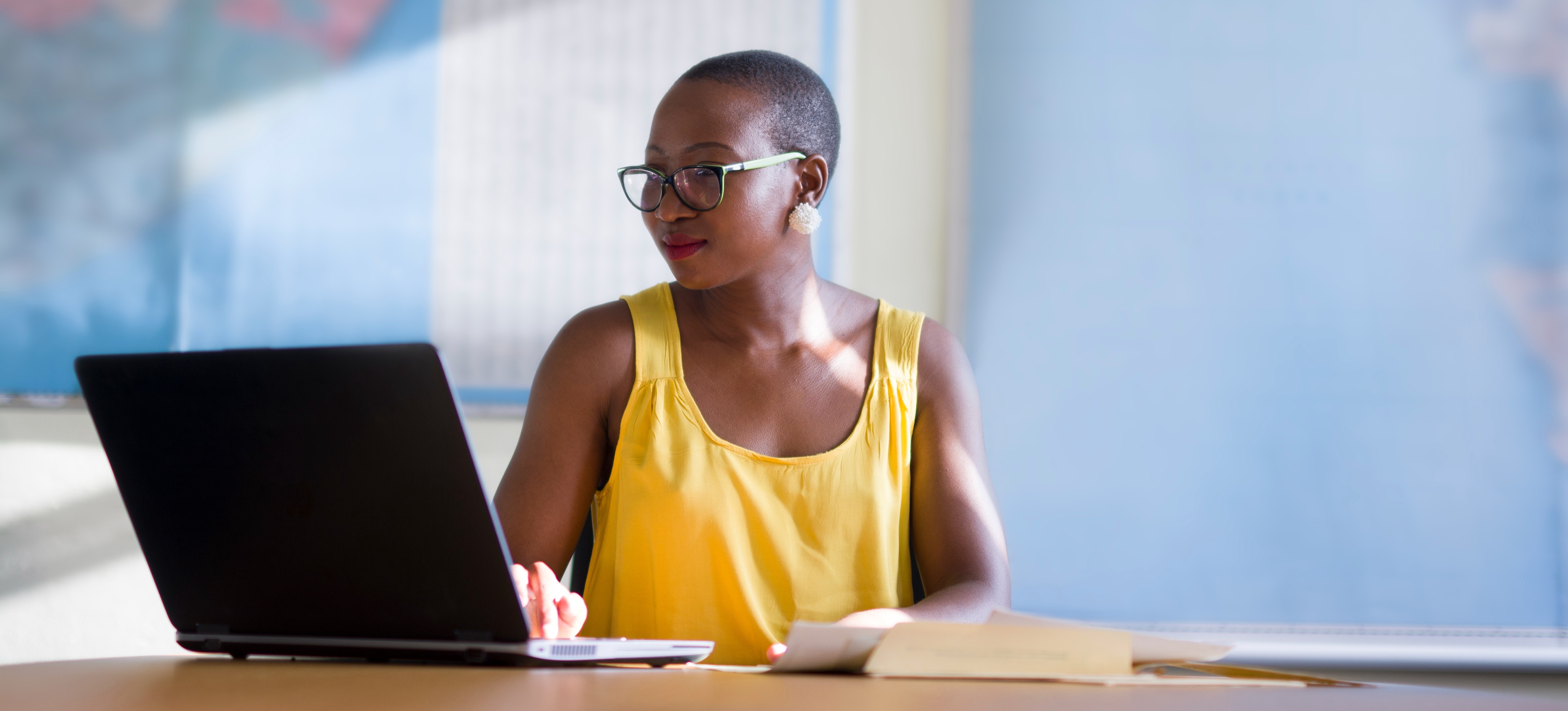 [featured image] A social media manager who has earned a marketing degree is smiling and typing on a laptop.