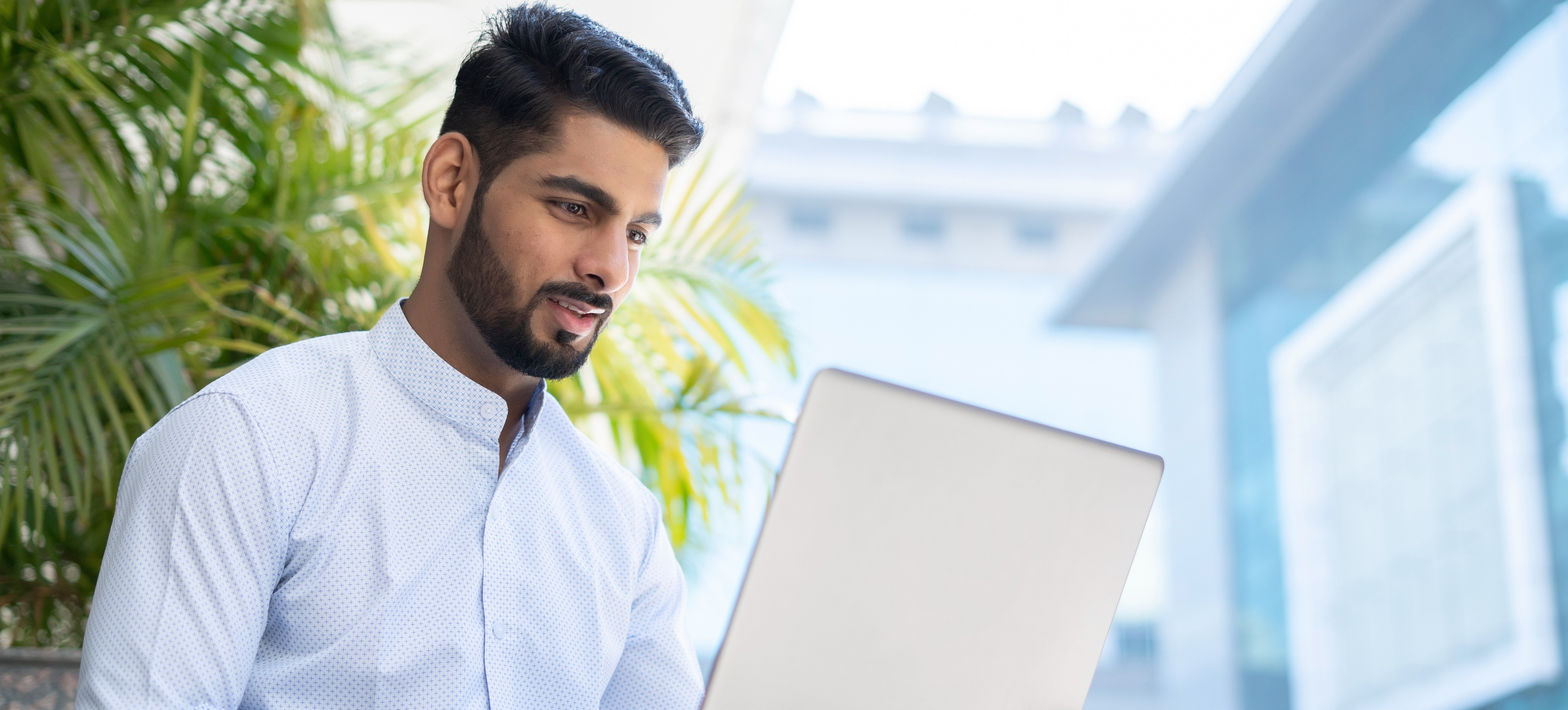 [Featured Image] A man on a computer is expanding his ai skills by checking for plagiarism.