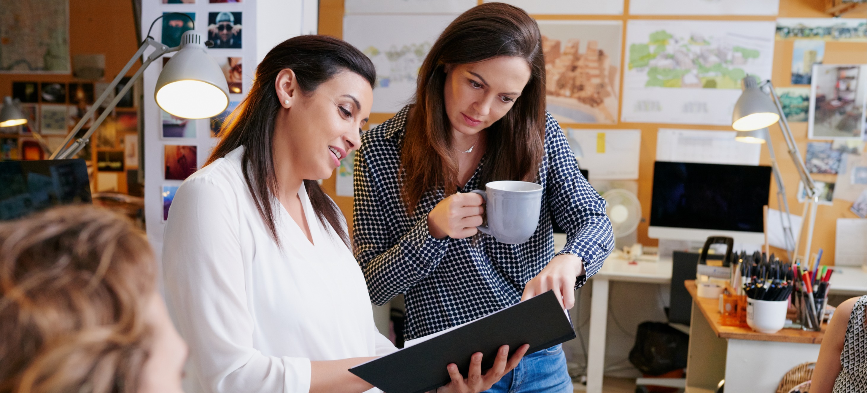 [Featured Image] A project manager discusses a project with an employee. 