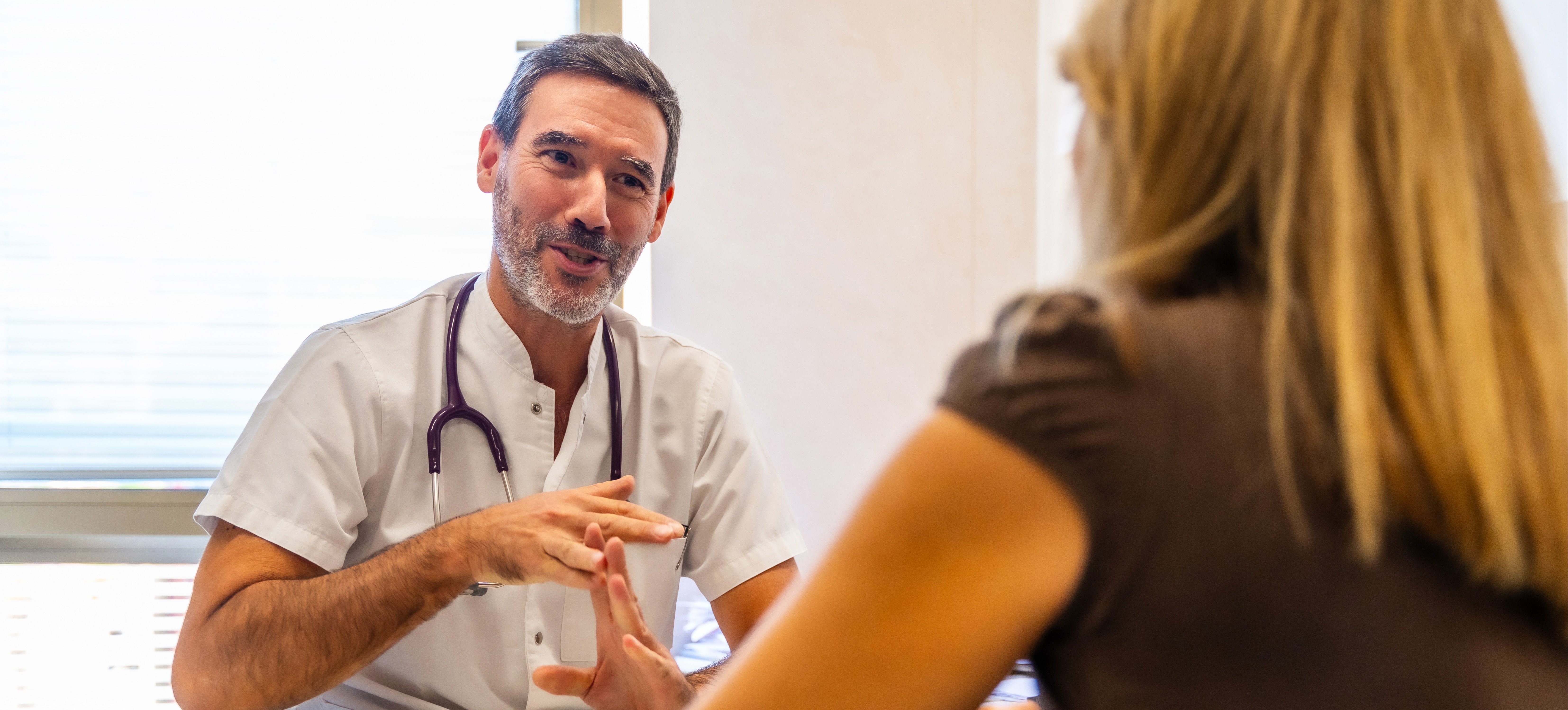 [Featured Image] A health science professional meets with a patient to discuss care.
