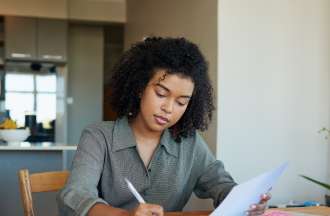 [Featured Image]:  Job applicant working on combination resume.