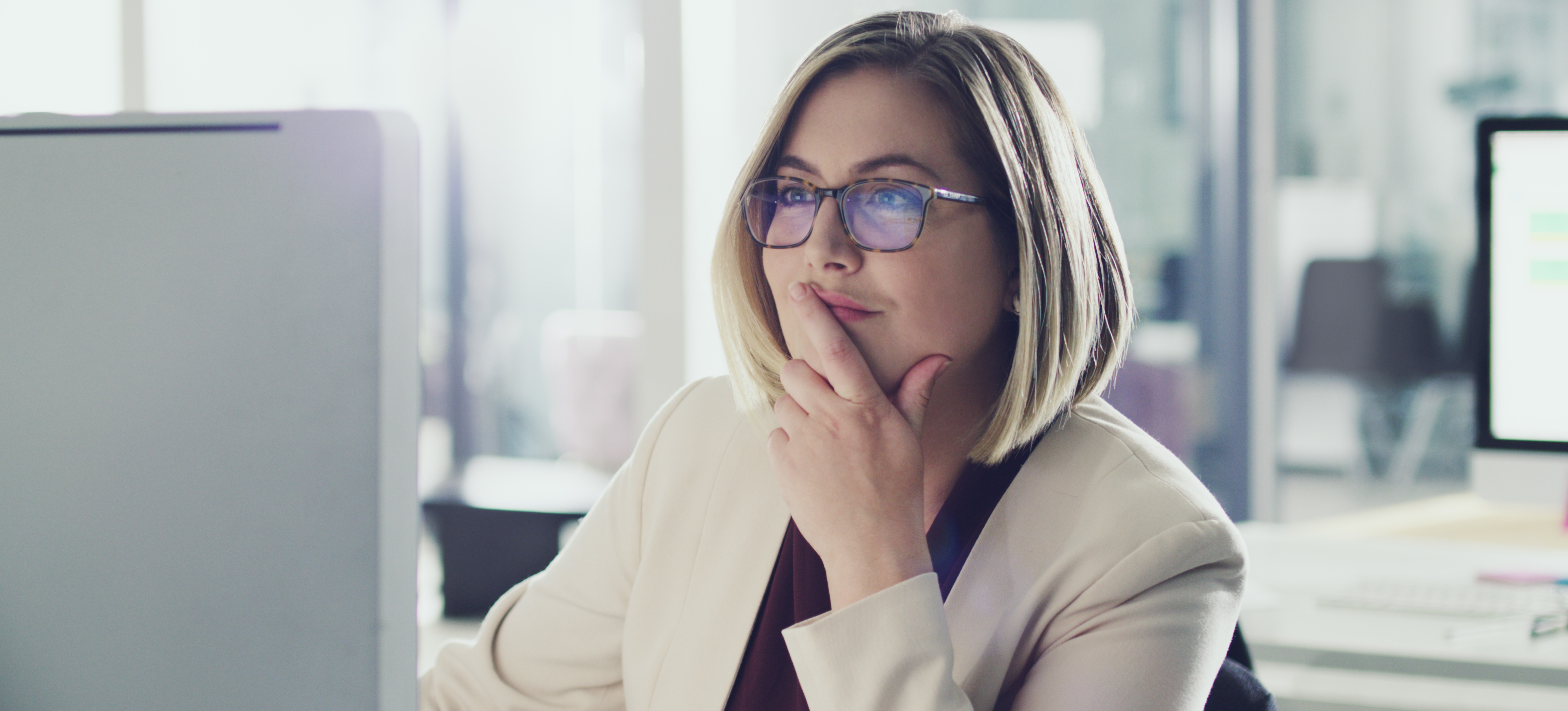 [Featured Image] A networking professional navigates the data link layer as they work on their computer in an office setting.
