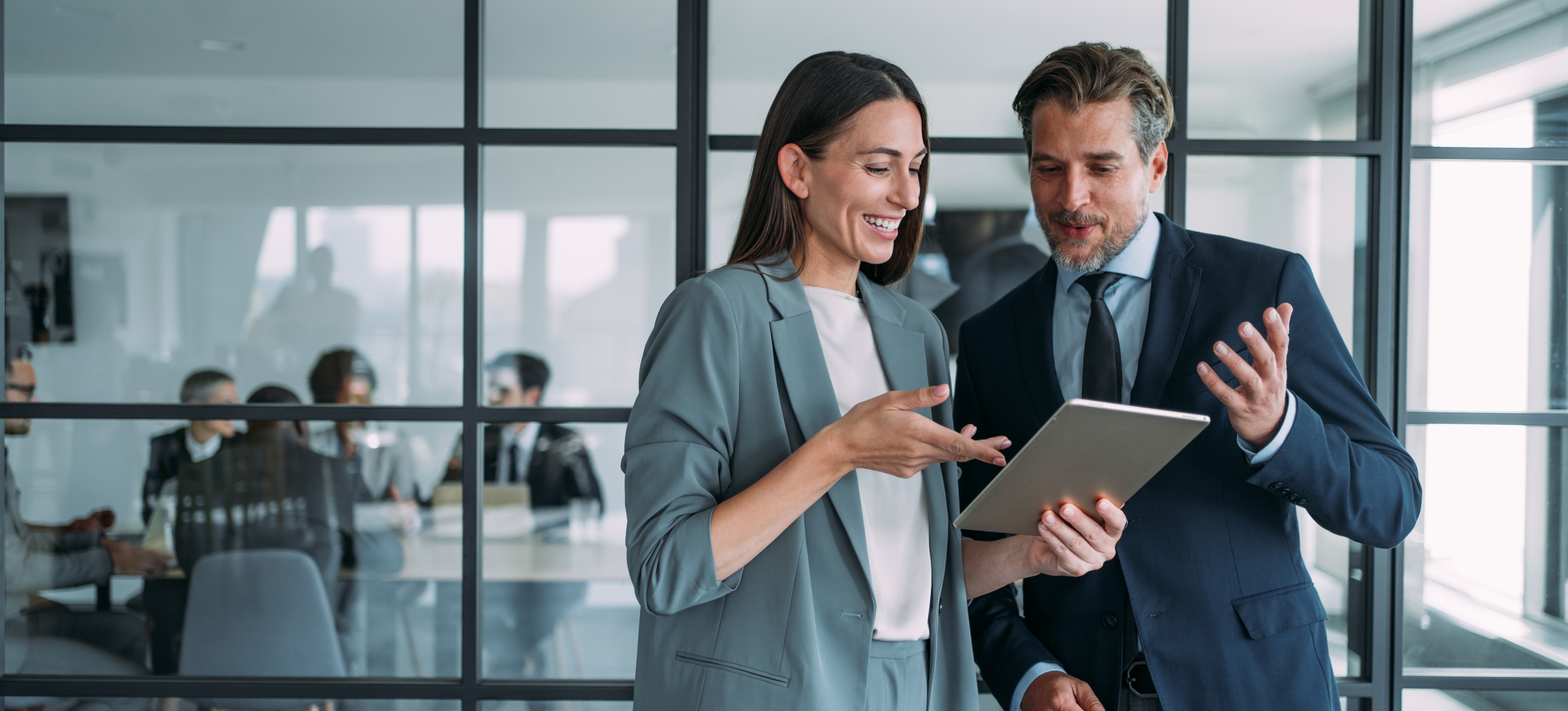 [Image en vedette] Deux cadres discutent de la signification de l'EVP, ou proposition de valeur pour les employés, alors qu'ils se tiennent dans un bureau devant une baie vitrée.