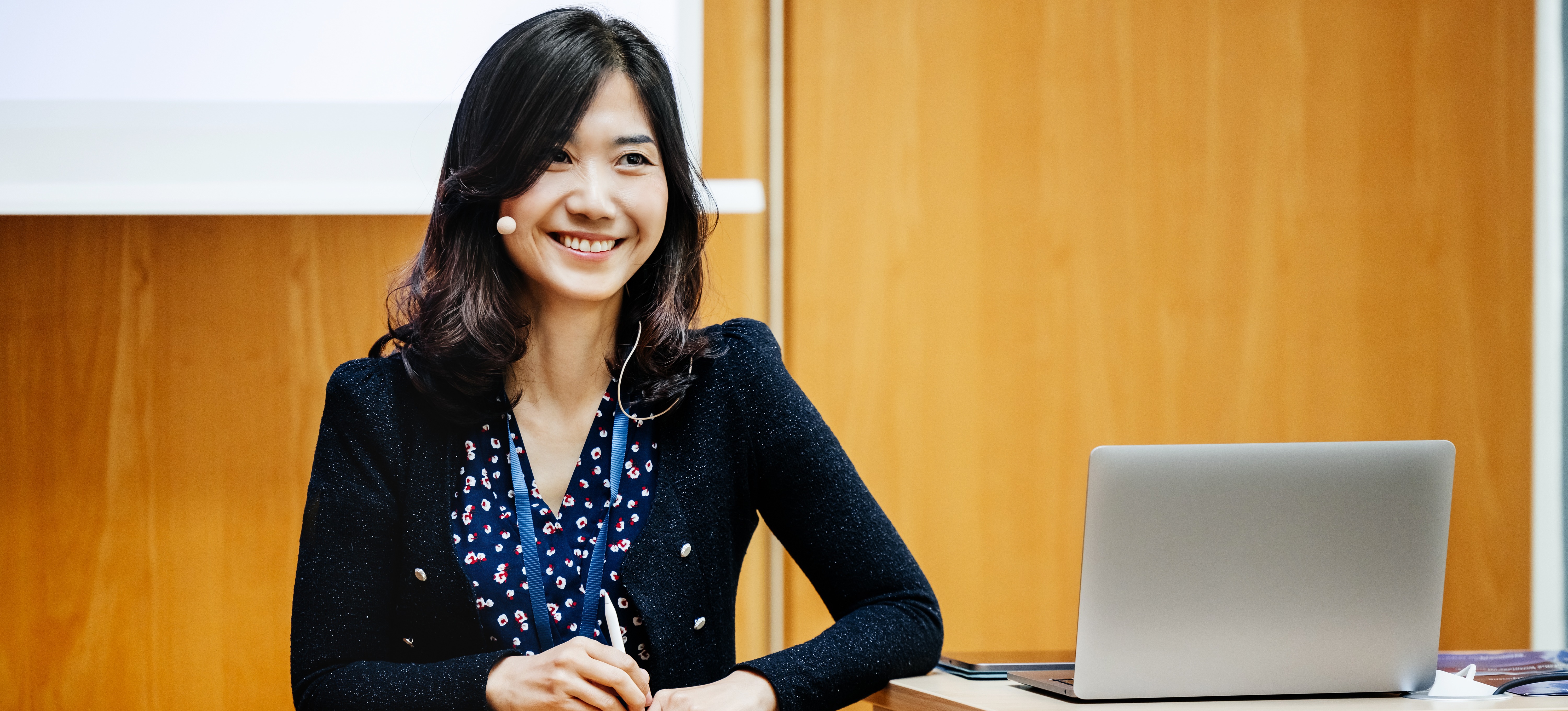 [Featured Image] An Agile coach stands at a podium, leading a training session.
