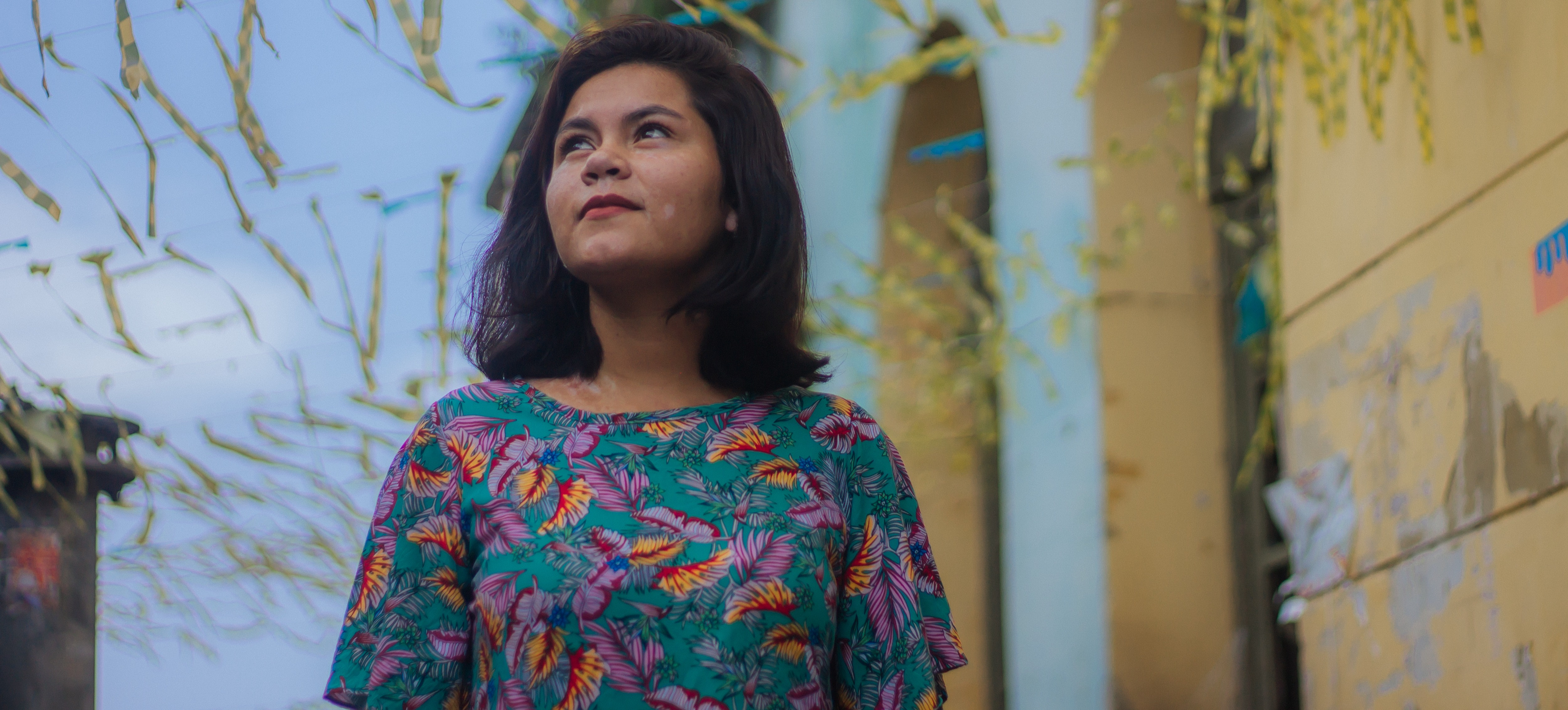 [Featured Image] A woman standing outside gazes at the sky.