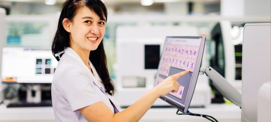 [Featured image] A medical technologist touches a monitor in a hospital setting.