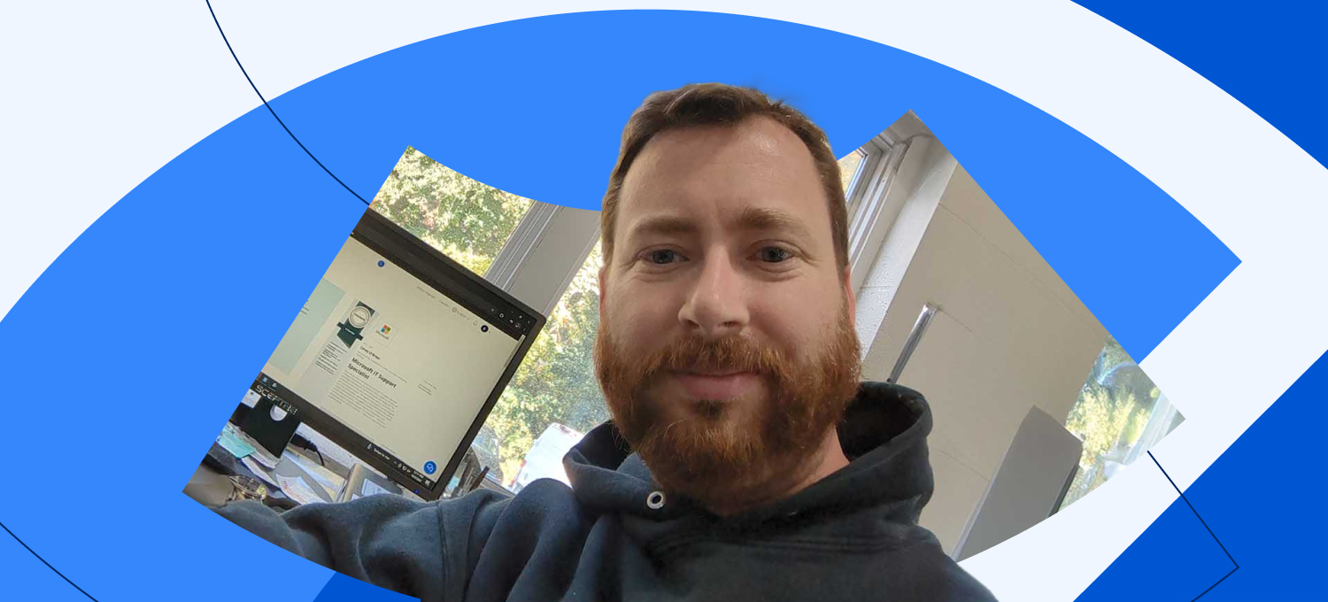 [Featured image] Coursera Plus subscriber Corey O'Brien sits in front of his desktop computer, which displays the certificate he earned after completing the Microsoft IT Support Specialist Professional Certificate.