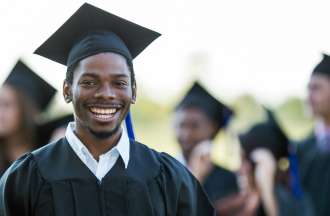 [Featured Image] A person in a black cap and gown holds a diploma after receiving a Bachelor of Arts Degree.