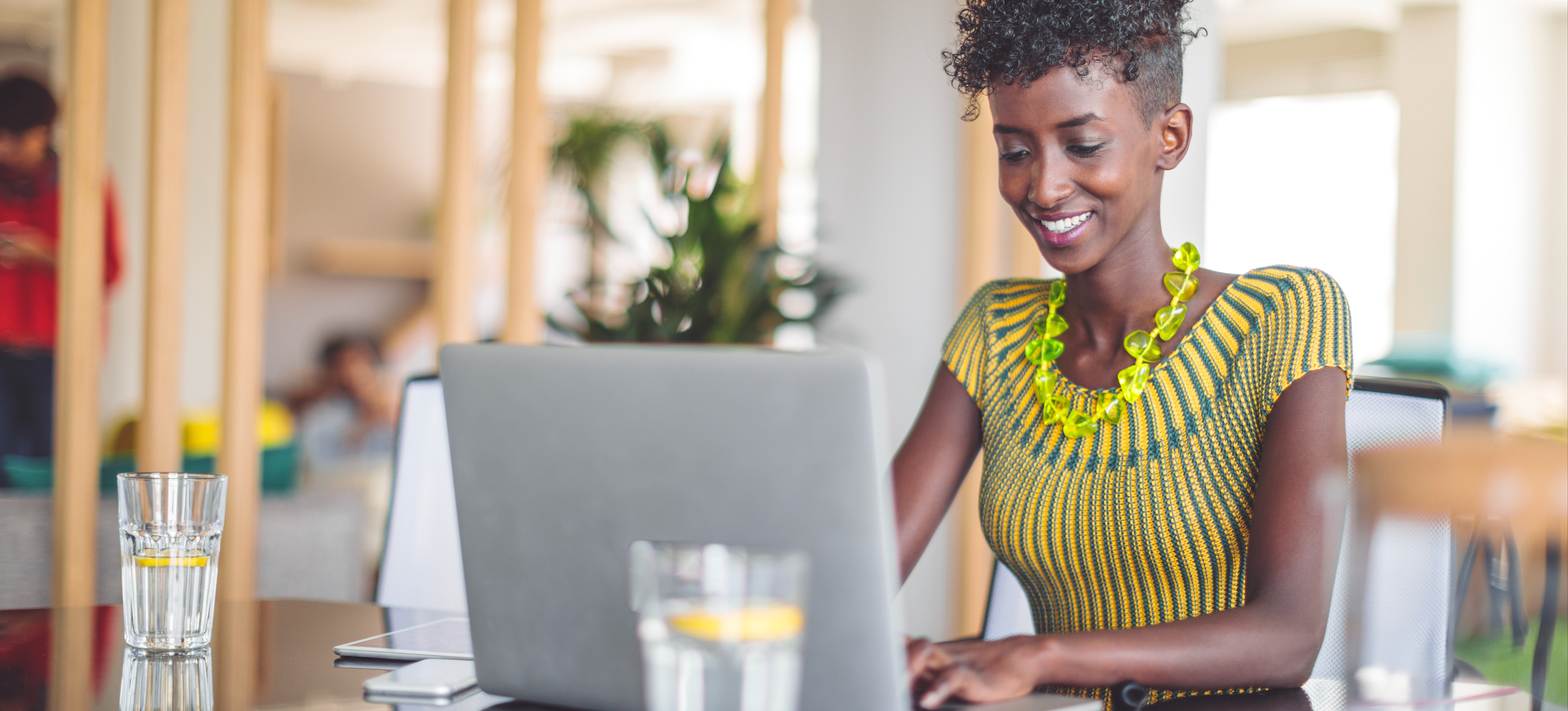 [Featured Image] A businesswoman smiles as they learn about supervised learning and unsupervised learning as part of her workplace’s training on machine learning. 
