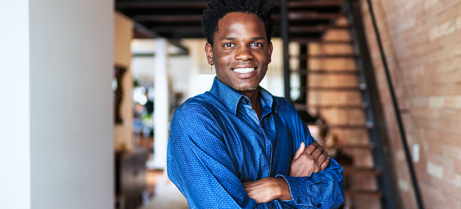 [Featured image] A cybersecurity analyst wearing a blue collared shirt stands with his arms crossed in front of him. He's looking at the camera and smiling.