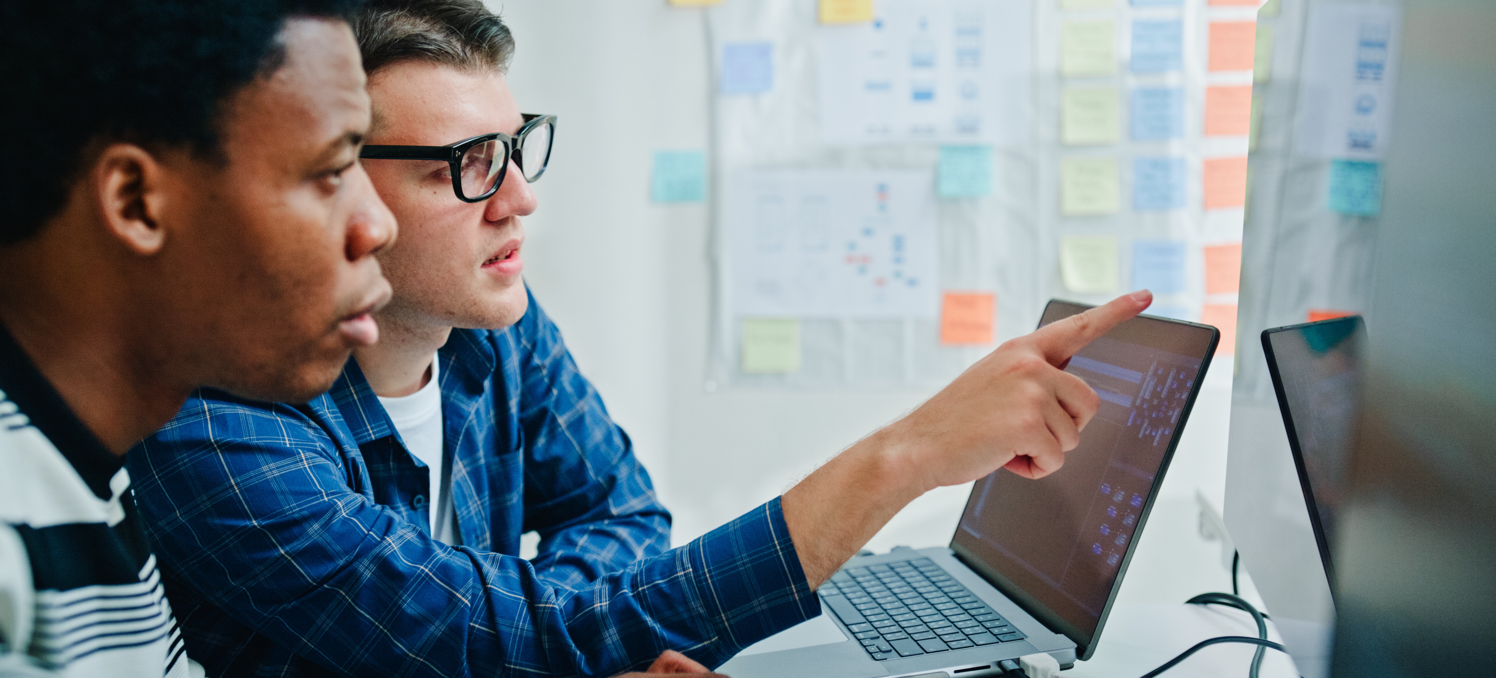 [Featured Image] Software development professionals interacting in a professional environment, discussing the concepts of GraphQL vs. REST APIs.
