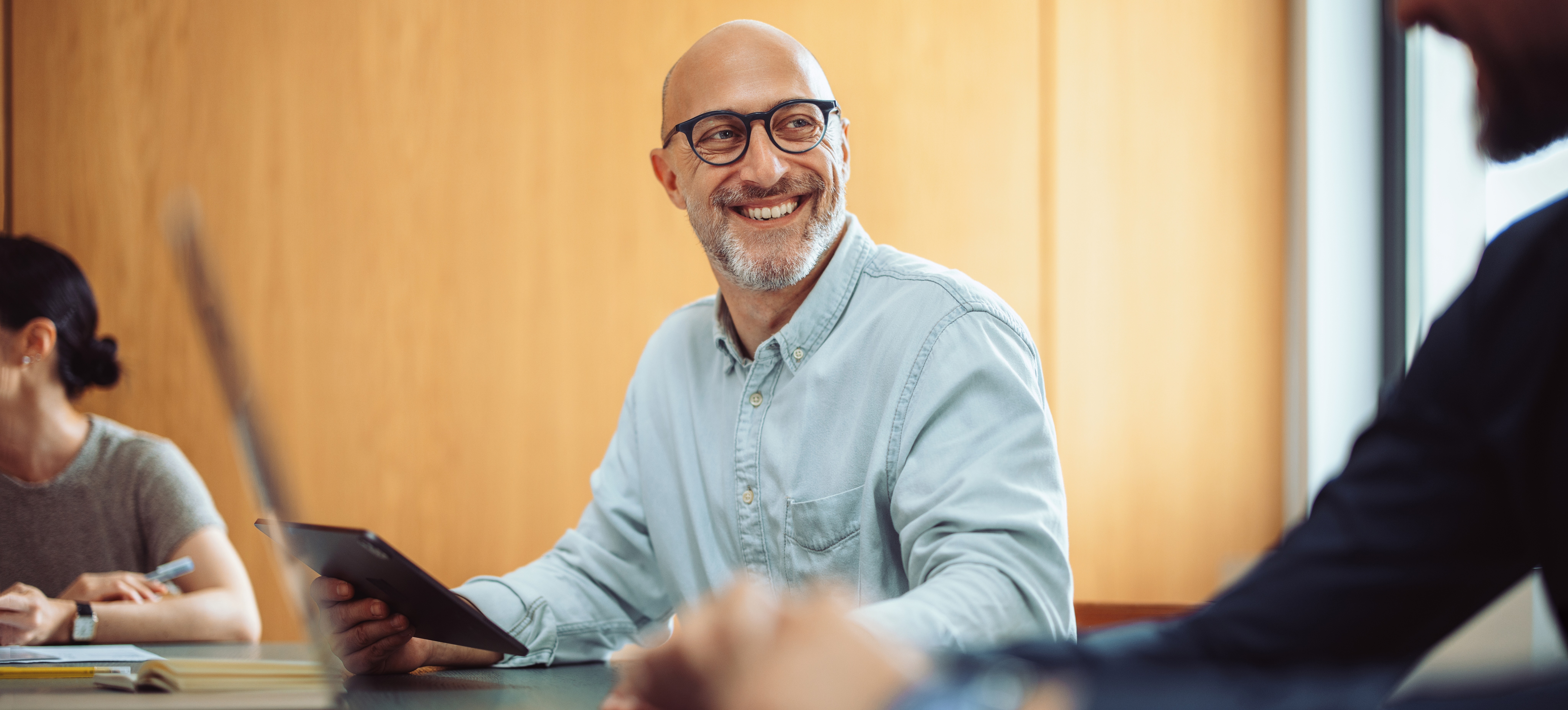 [Featured Image] A network architect meets with a team to determine business needs.
