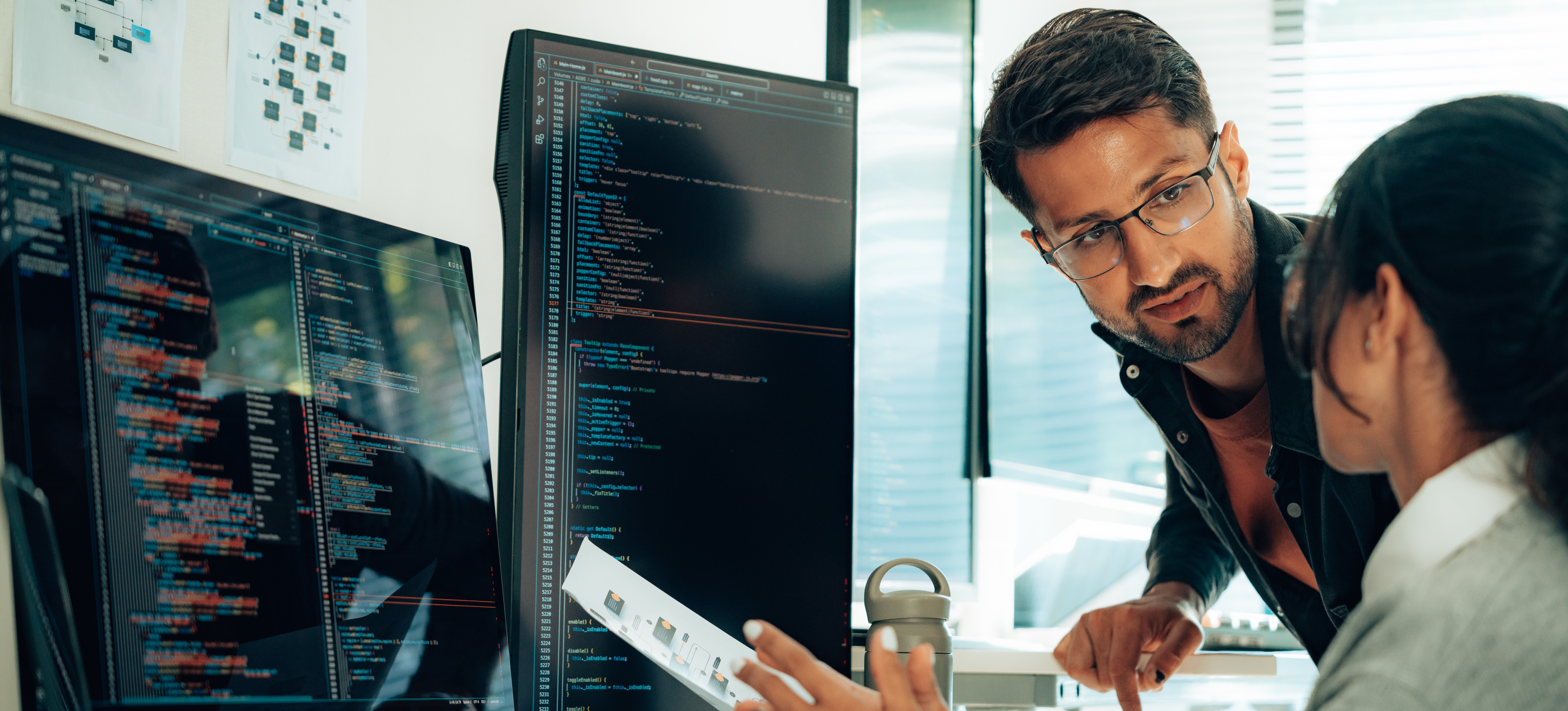 [Featured Image] Cybersecurity professionals collaborate, discussing identity access management (IAM) tools and techniques in a work environment.
