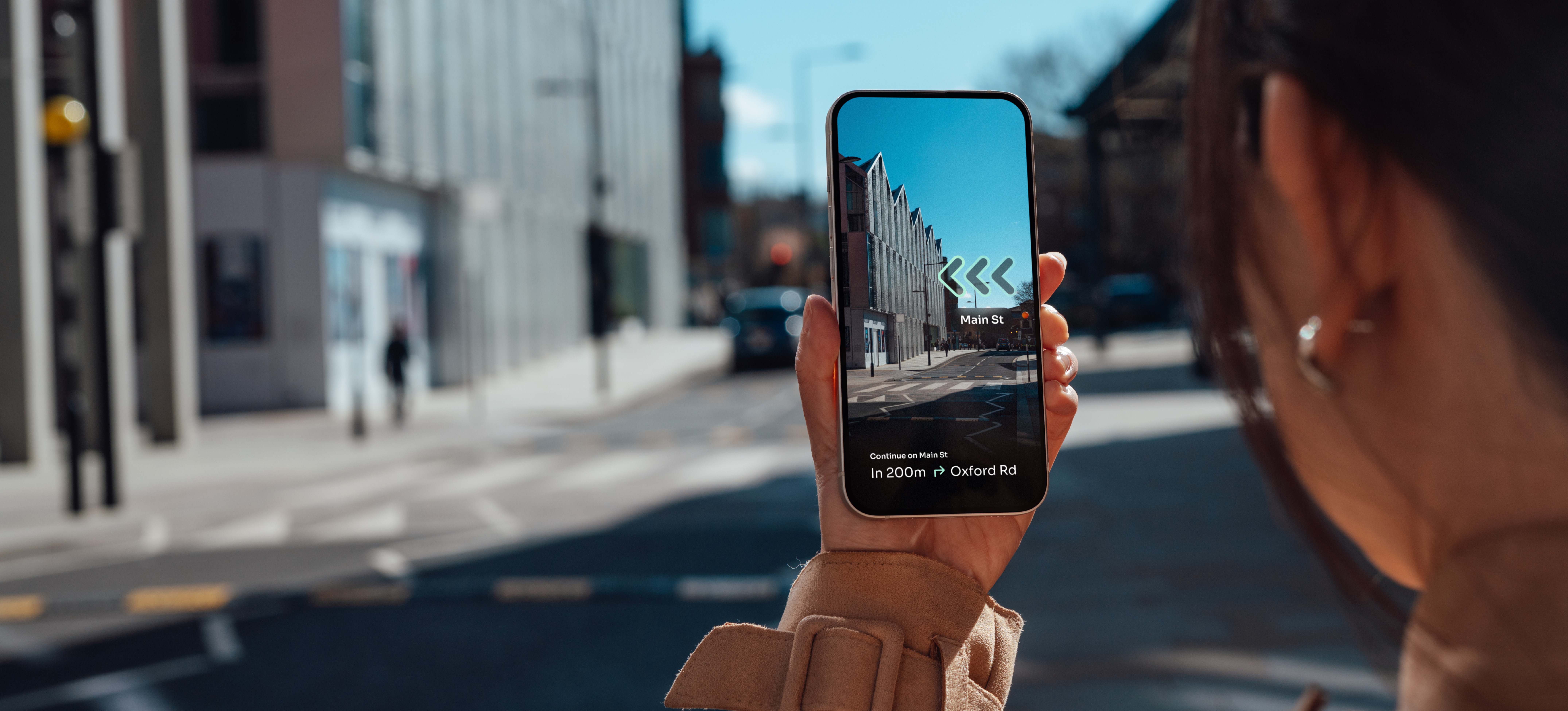 [Image en vedette] Une femme utilise une application de réalité augmentée pour trouver son chemin dans une ville.
