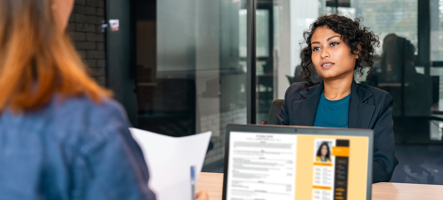 [Featured Image] A graphic designer discusses their graphic design resume during a job interview.
