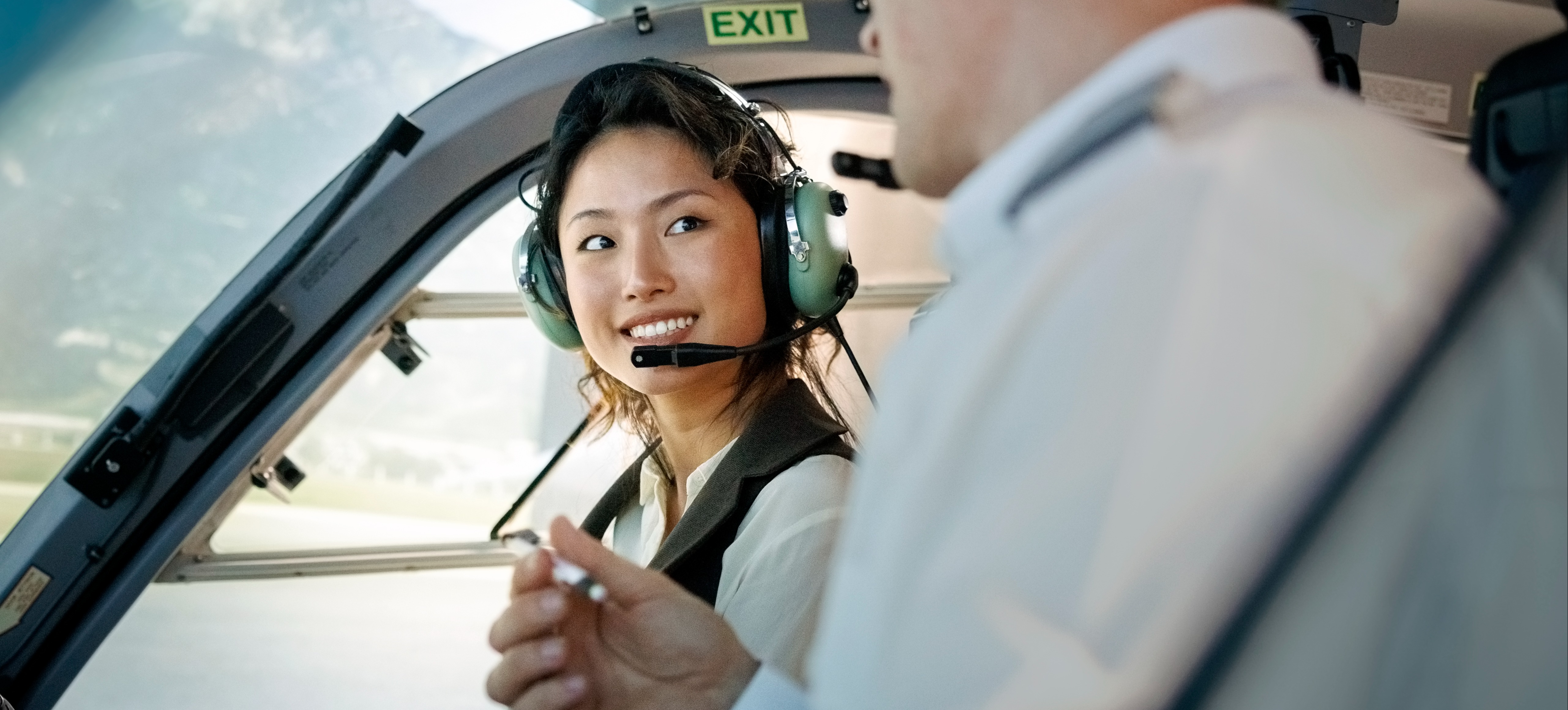 [Featured image] A trainee pilot listens to their instructor during flight training inside an airplane.