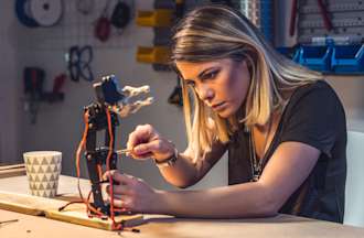 [Featured image] A photonics engineer works on light-based equipment with tools in a lab.