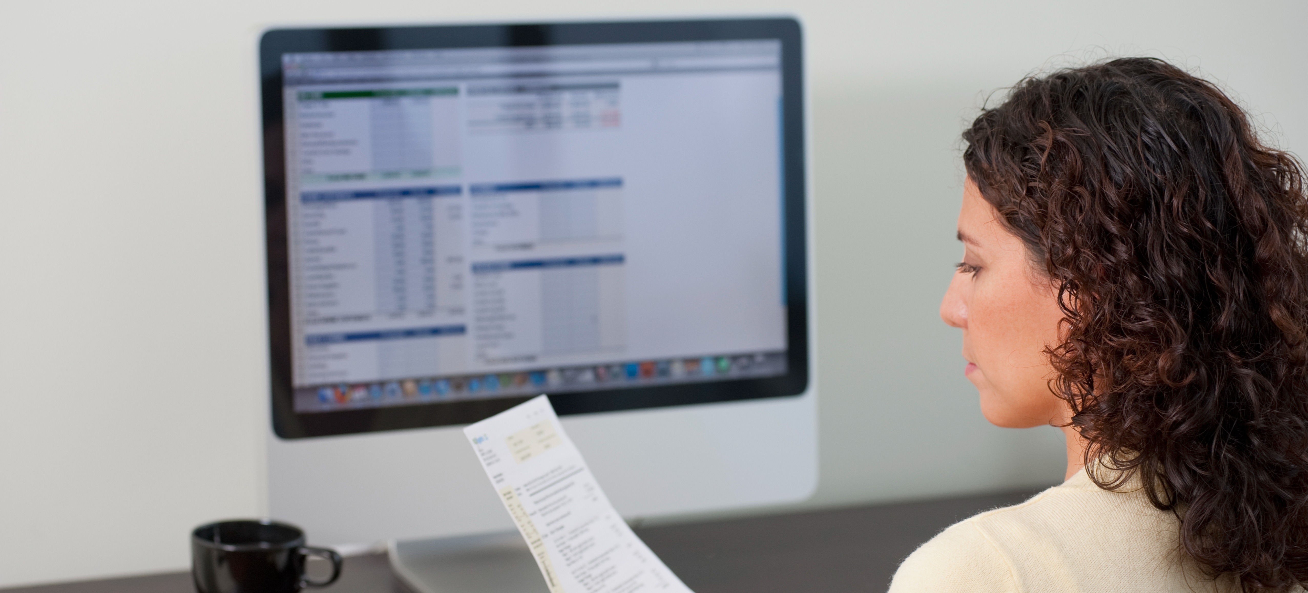 [Featured Image] A woman sitting at a desk is working on google sheets using the IF-THEN formula to streamline her tasks.