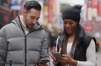[Featured image] A couple uses GPS navigation, a big data example, on their smartphones to get around a city. 