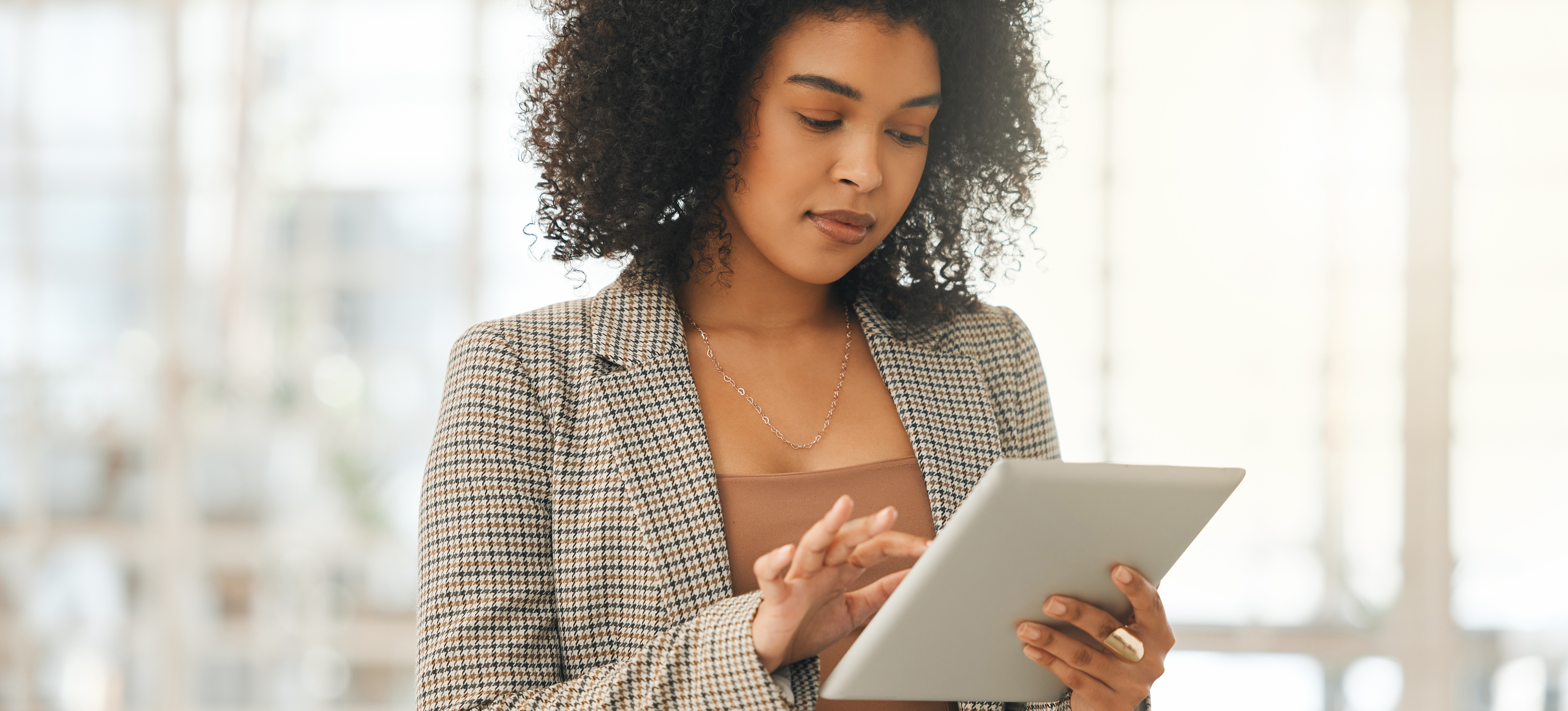 [Featured Image] A human resources professional looks at HR analytics on her tablet.