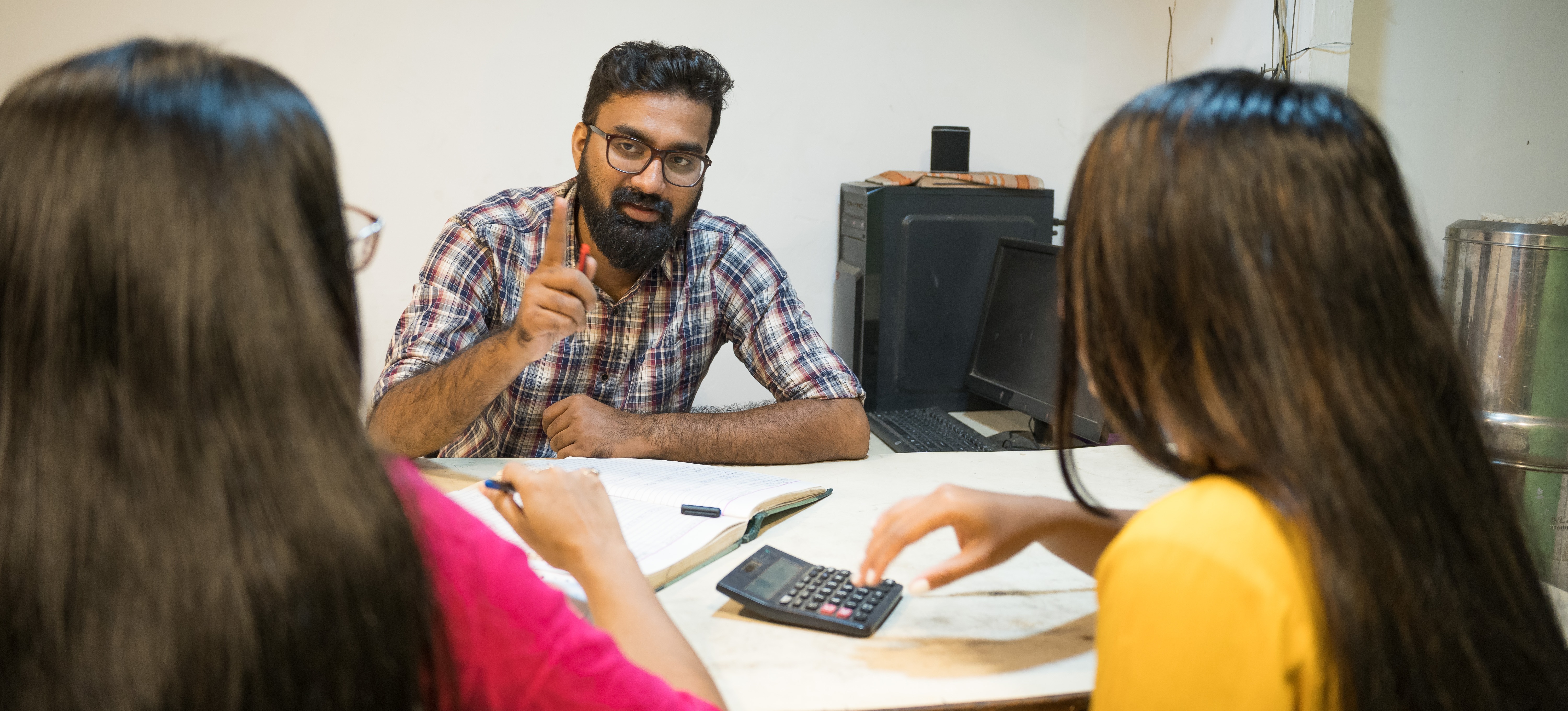 [Featured Image]: Three people working in finance management discuss a plan for a client.