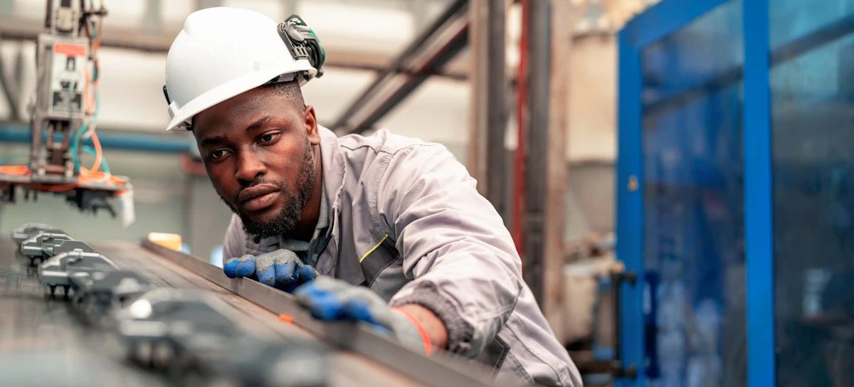 [Featured Image] A quality control inspector visually assesses products to evaluate AI in manufacturing at work after they undergo an AI-based assessment designed to detect defects.  
