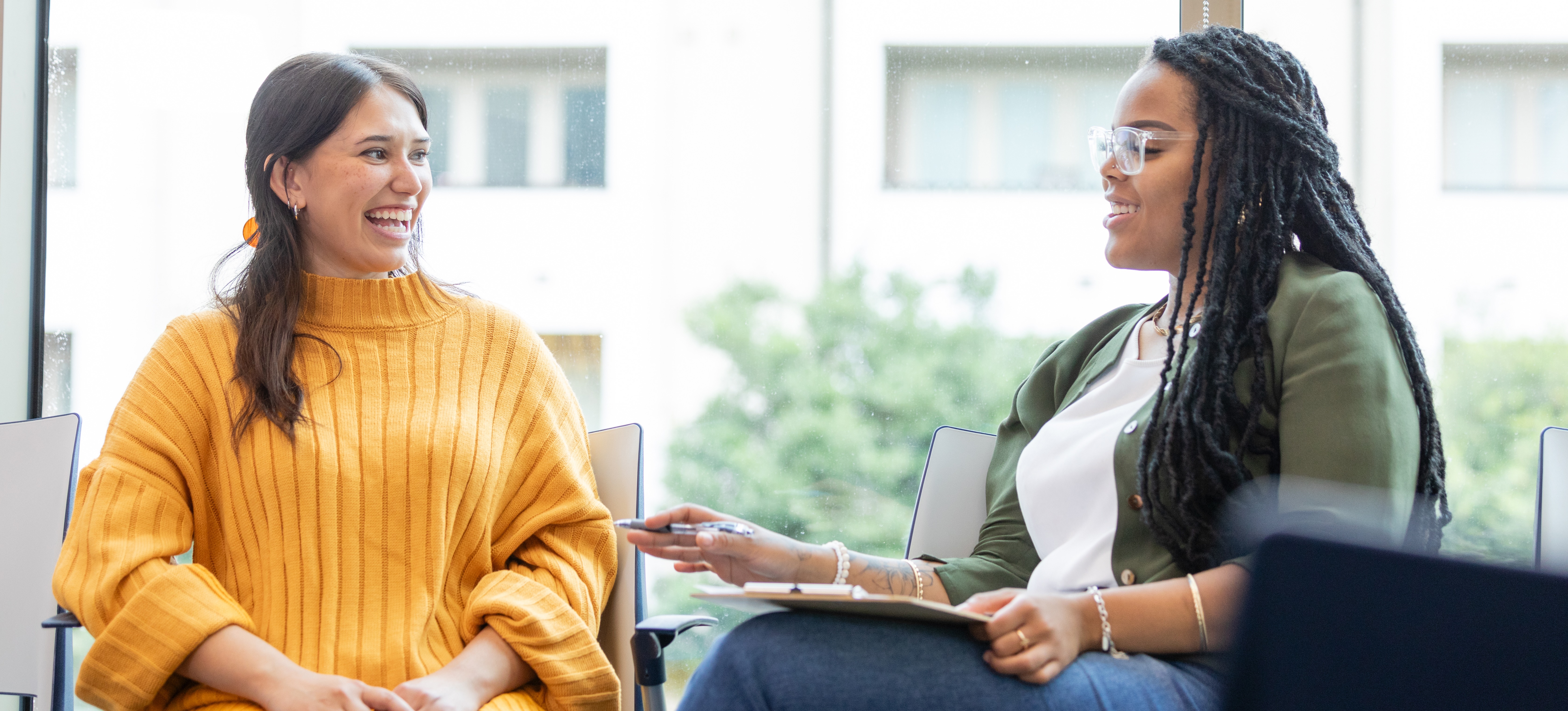 [Featured Image] An HR coordinator meets with an employee for an informal discussion.
