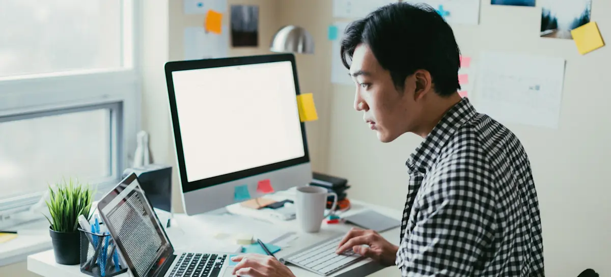 [Featured Image] A person in a checkered shirt searches programming languages to learn on their computer. 
