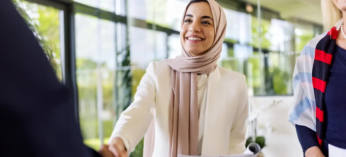 [Featured image] A woman in a white blazer shakes hands with a sales lead from her company's sales pipeline.