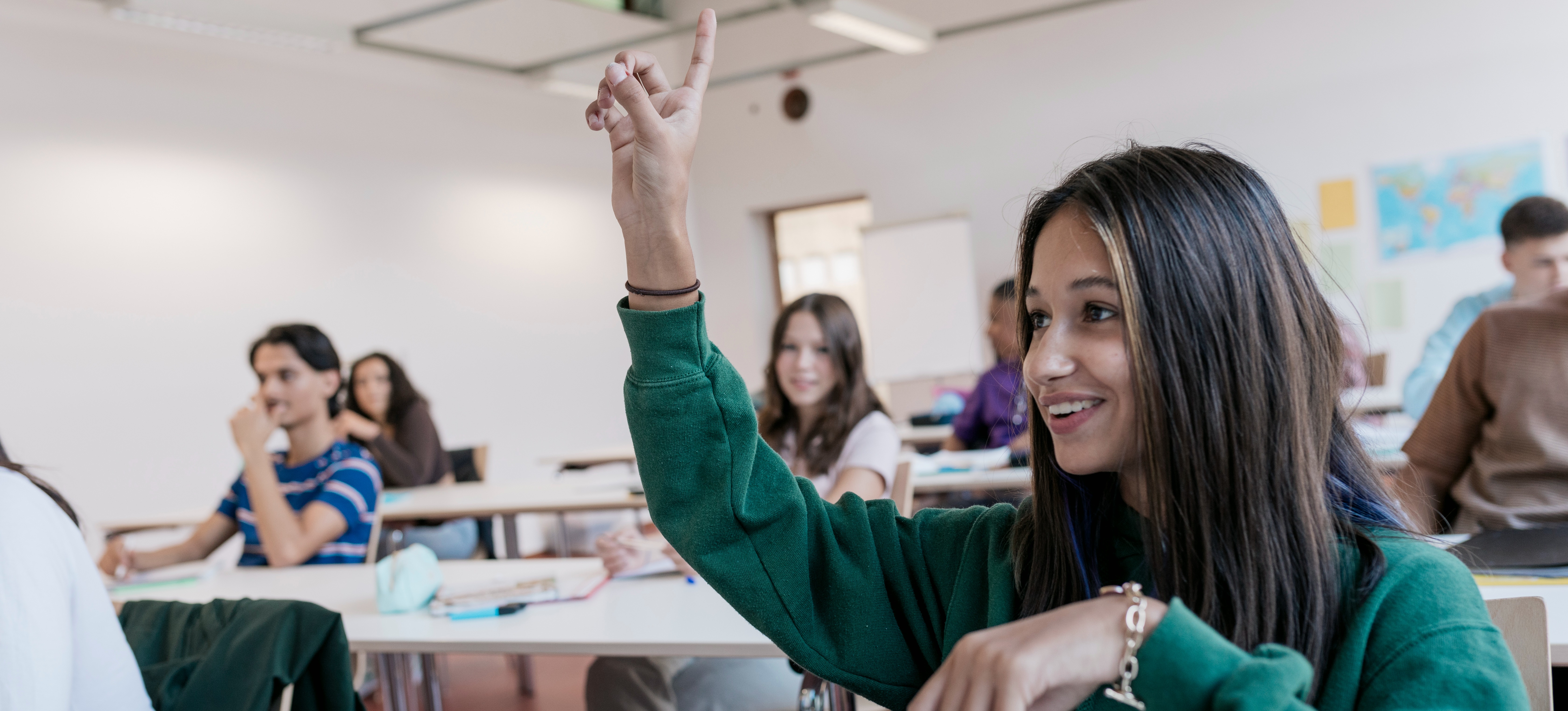 [Featured Image] A highschool student in a classroom is raising her hand to ask about clearing since she missed the application deadline to her university of choice.