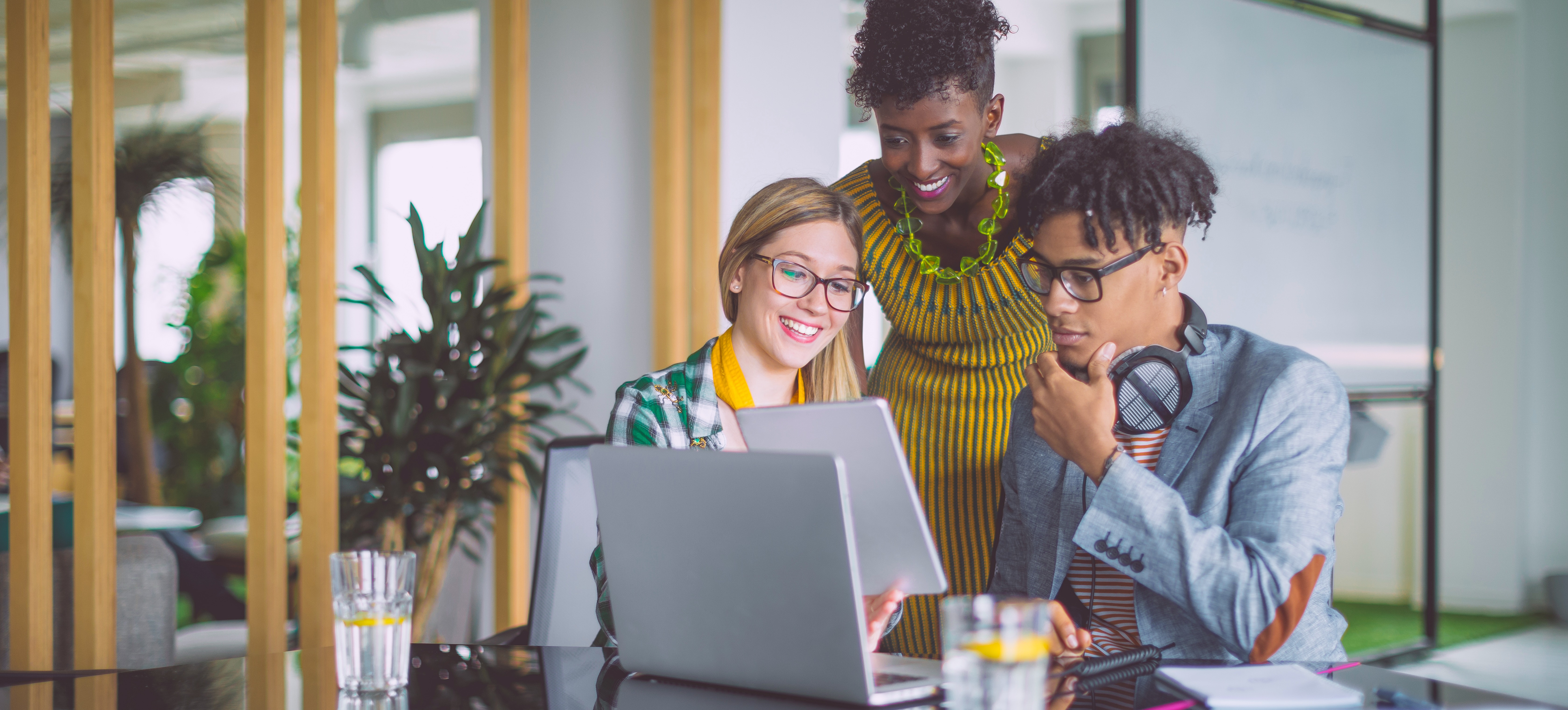 [Featured Image] Diverse business team reviews documents at a conference table, collaborating on a project that could be found in many AI internships in an office setting.
