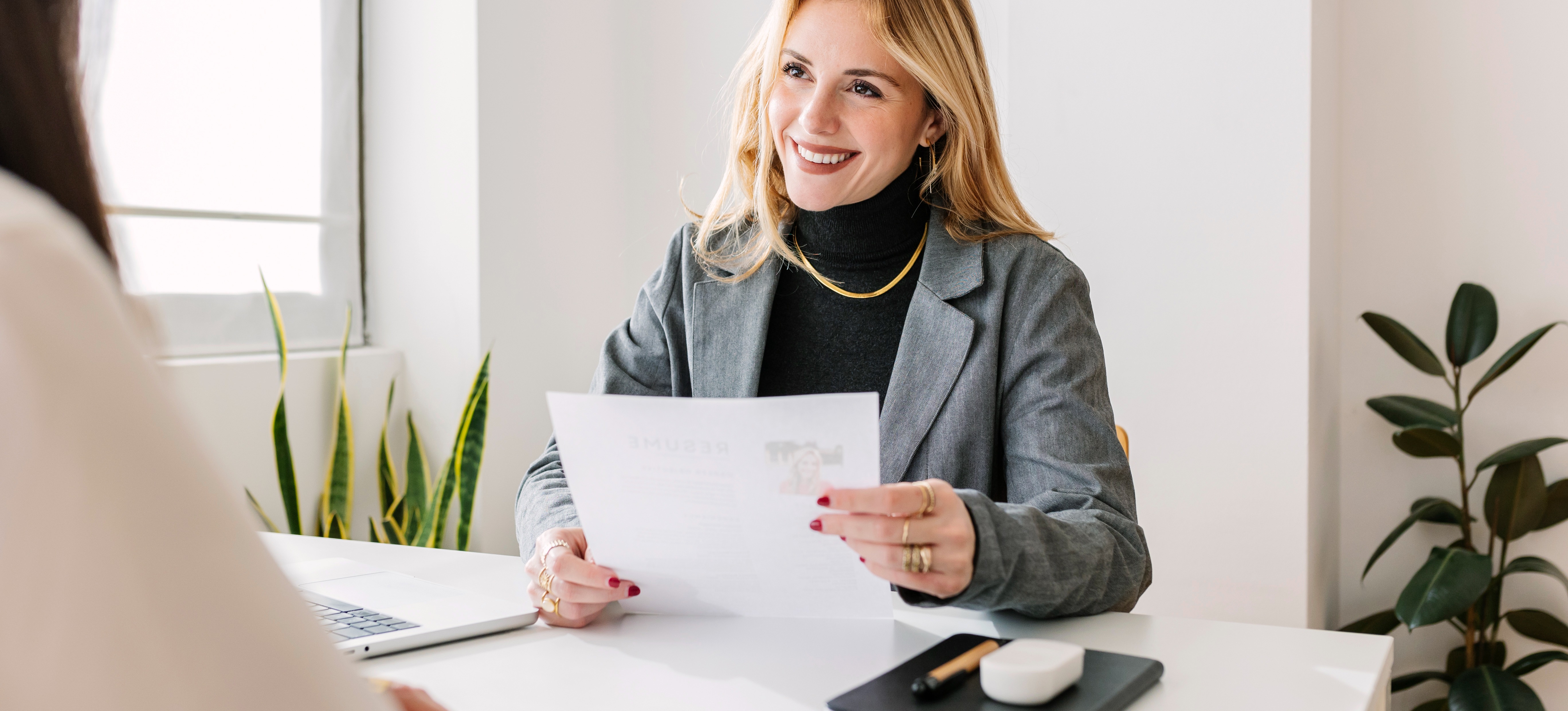 [Featured Image] A human resources professional uses her HR skills to conduct a job interview.  