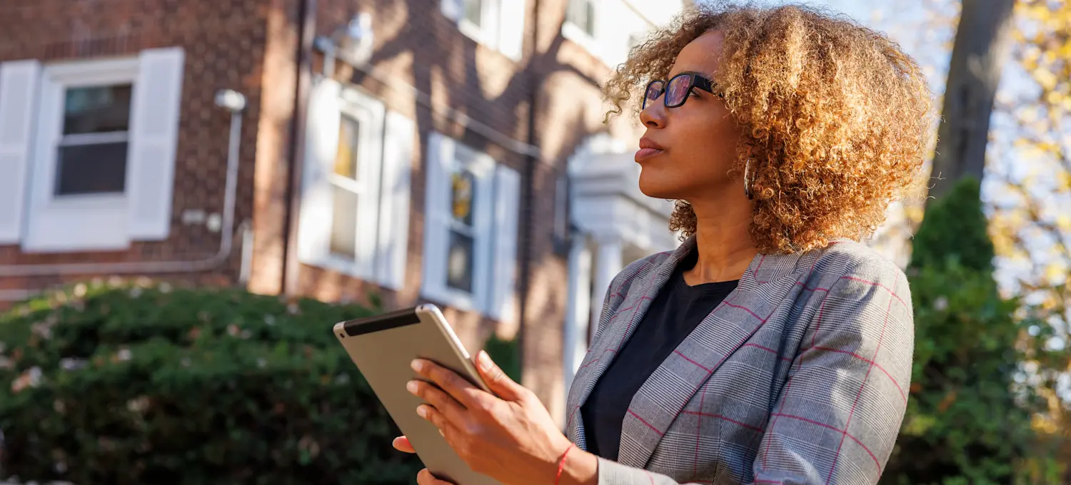 [Featured Image] A real estate appraiser inspects a house and takes notes for the appraisal.
