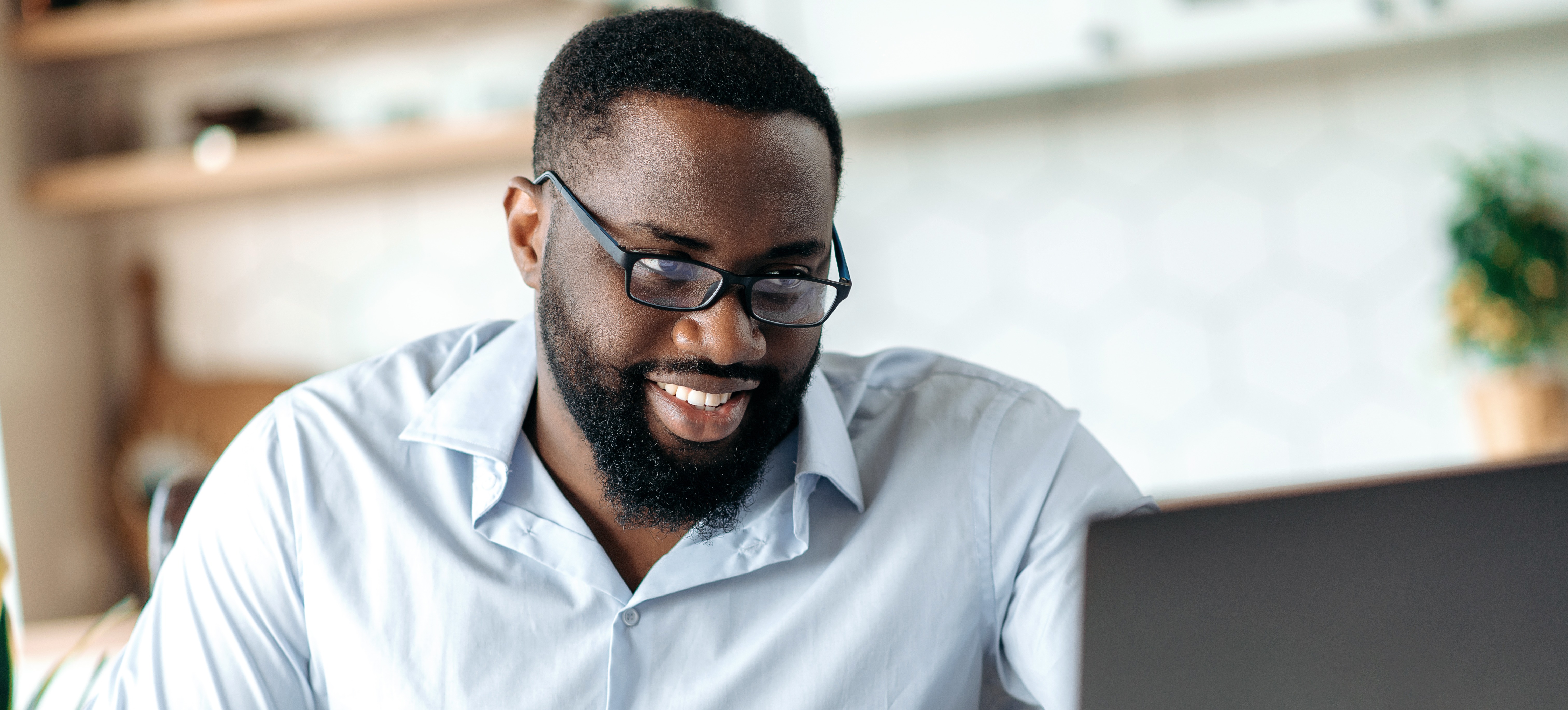 [Featured Image] A man writes in a notebook and looks at his laptop as he takes a data science course online and learns about topics like star schema vs. snowflake schema.
