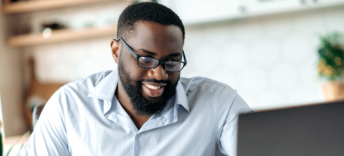 [Featured Image] A man writes in a notebook and looks at his laptop as he takes a data science course online and learns about topics like star schema vs. snowflake schema.
