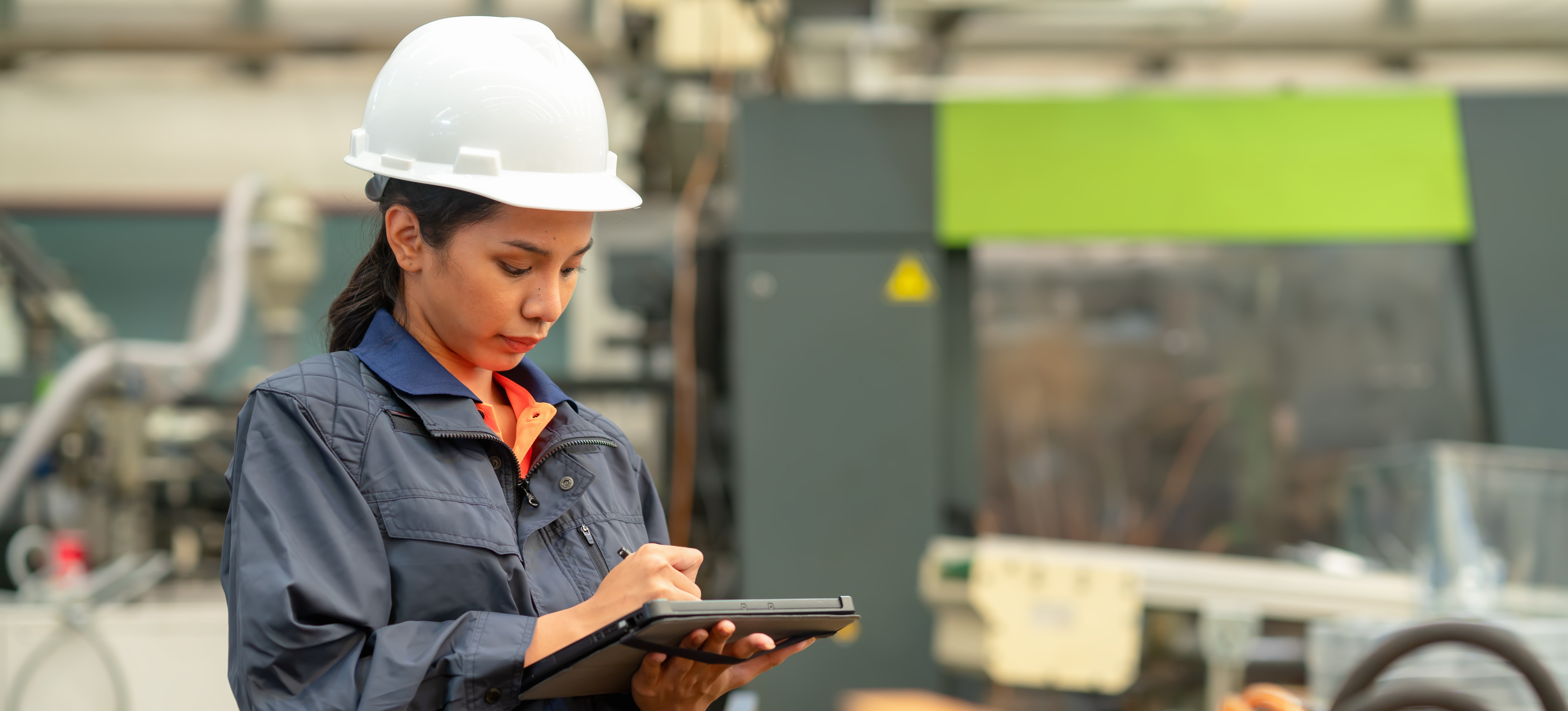 [Featured Image] A supply chain analyst consults data at a worksite.
