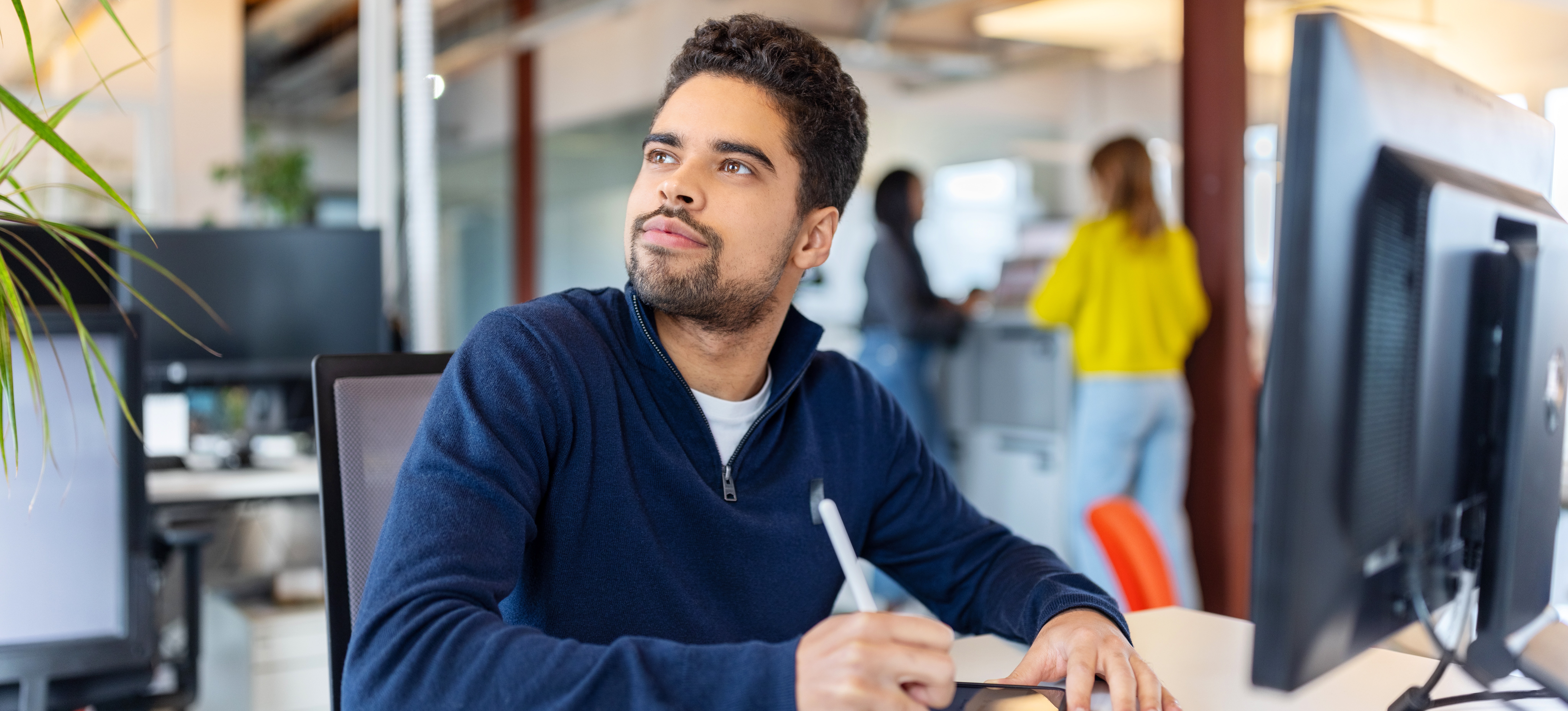[Featured Image] A young worker uses abstract thinking in the workplace to brainstorm solutions and write them on a tablet.
