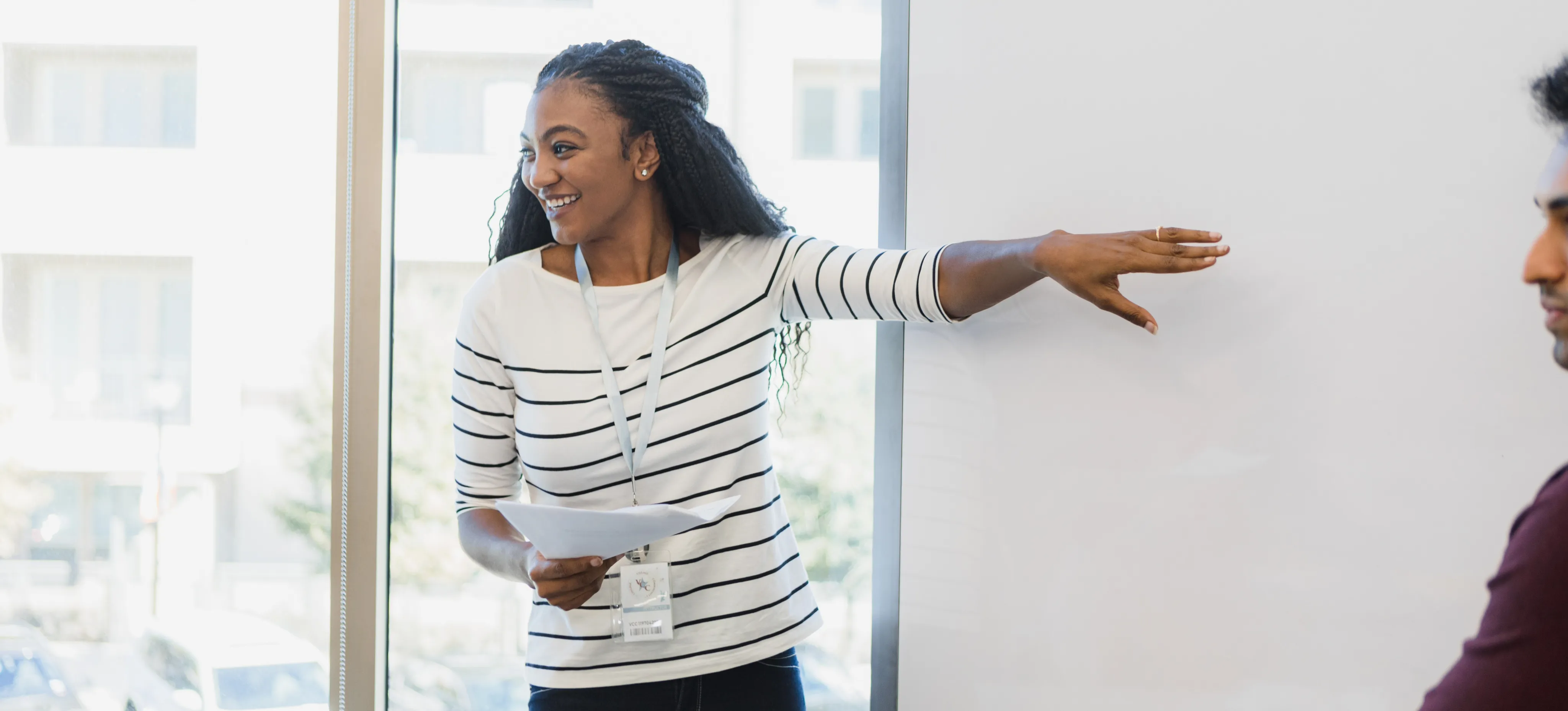 [Featured Image] A young professional defines professional development goals whilst leading a training course for a company’s employees.
